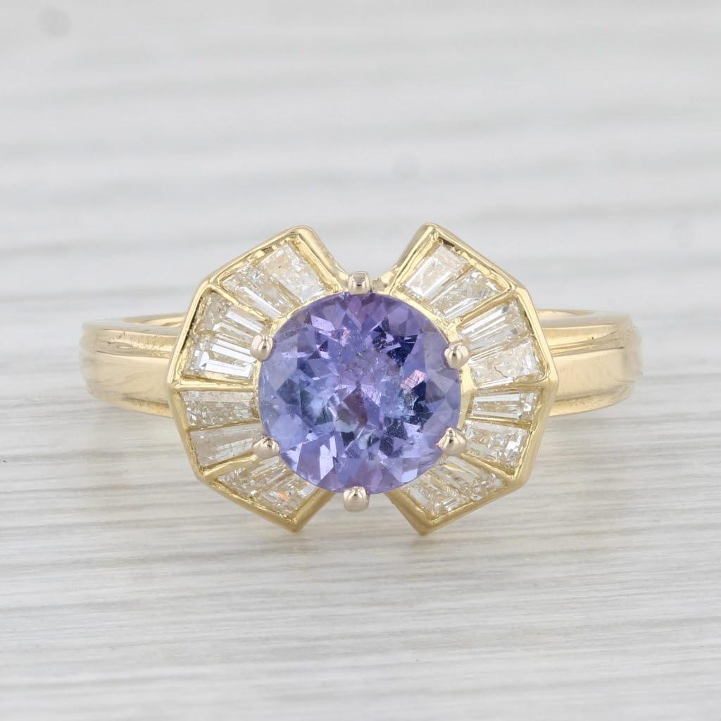Gemstone Information:
- Natural Tanzanite -
Carats - 1.38ct 
Cut - Round Brilliant
Color - Purple
Treatment - Heated

- Natural Diamonds -
Total Carats - 0.70ctw
Cut - Baguette
Color - F - G
Clarity - VS2

Metal: 18k Yellow Gold
Weight: 4.6 Grams