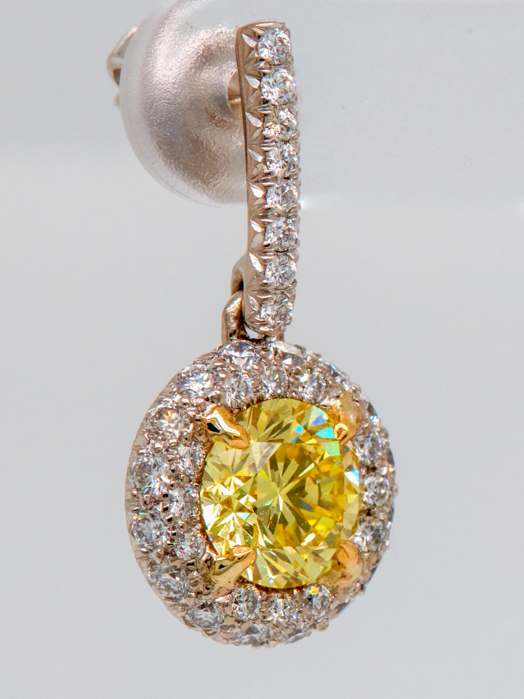 Contemporary 2.09 Carat Fancy Vivid Yellow Diamond Drop Earrings with Halo, GIA Report For Sale
