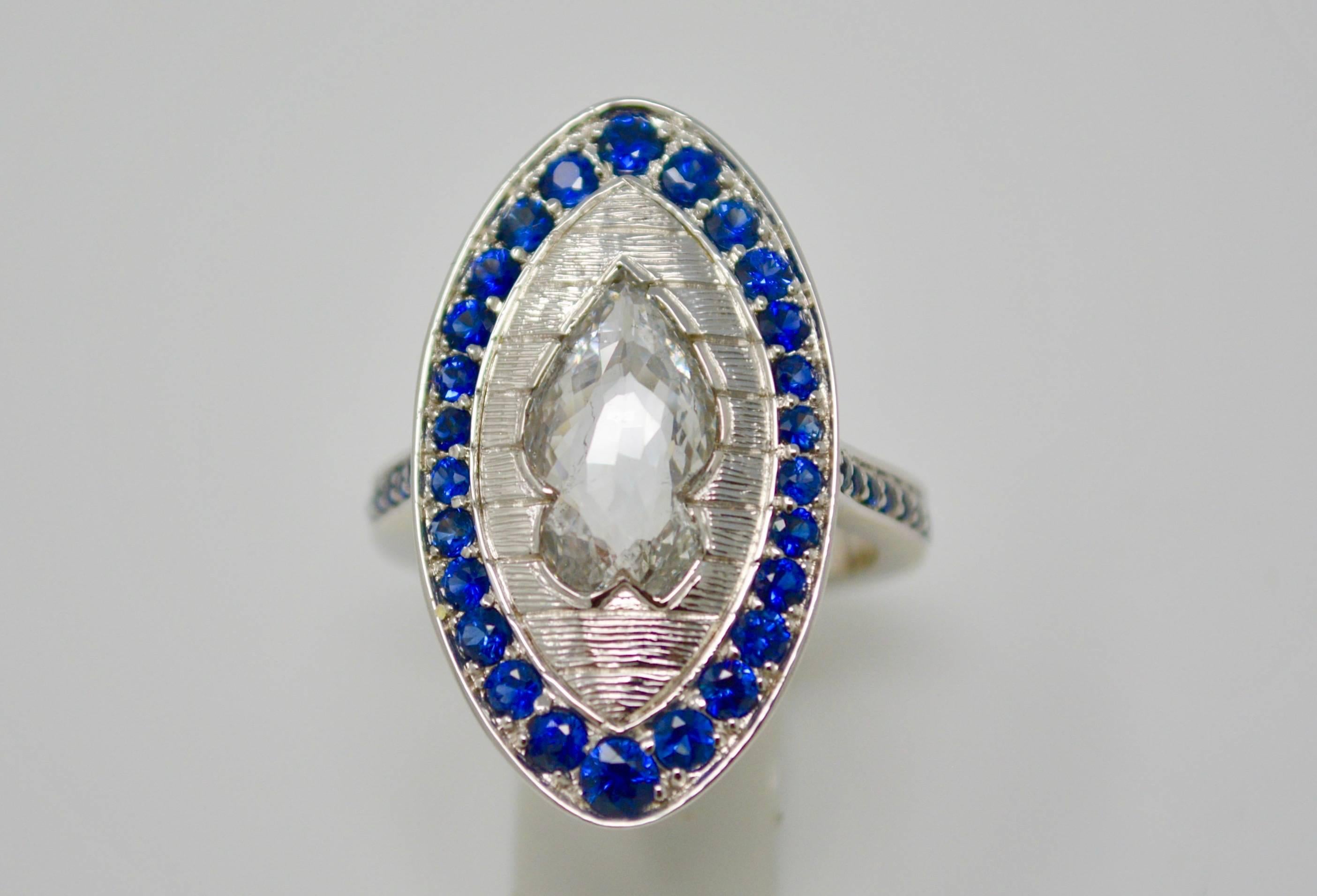 This unique and one of a kind ring features a white rose cut diamond specially cut in a fish shape weighing 2.09 carats, within a circular cut blue sapphires surround weighing 0.70 carats ,mounted in 18k white gold .  