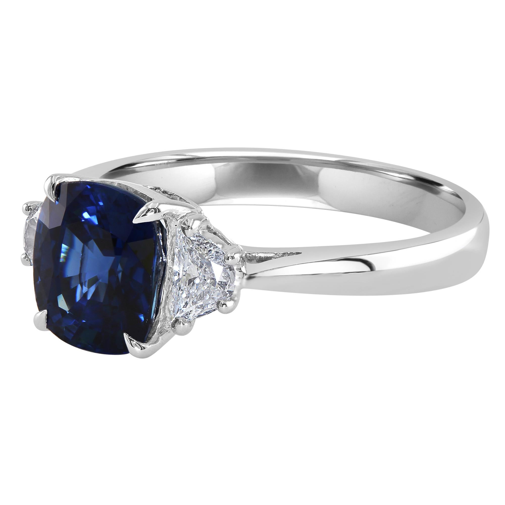 This ring features a beautiful 2.09 carat cushion blue sapphire, set between two half moons, 0.24 carat total weight.

Enjoy a stunning blue sapphire three-stone-ring that would make for an amazing and unique colored gemstone engagement ring. The