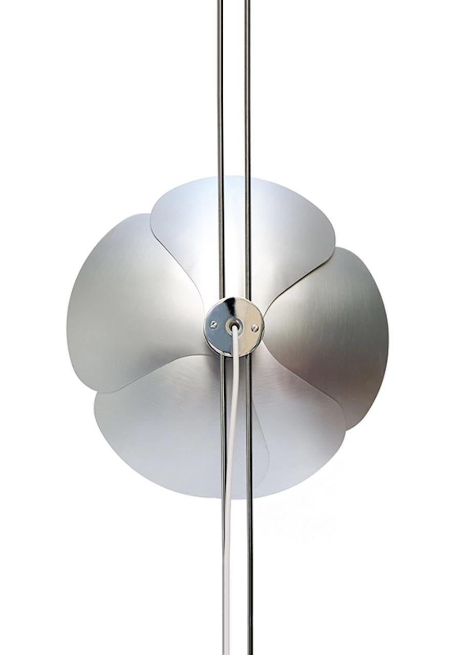 In 1967, Olivier Mourgue invented a flower shaped lighting device, made of aluminum petals fixed on two chromed metal wires, for sconces, ceiling lights and standing lamps. He used this silver caped bulb, which was new at the time, and produced very