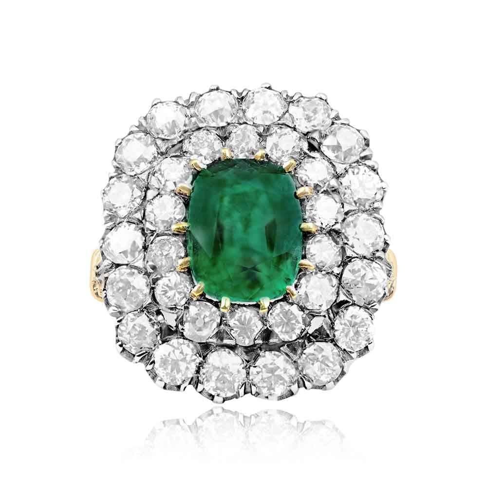 An enchanting ring showcasing a 2.09-carat cushion-cut emerald center, embraced by a double halo of old European cut diamonds. The shoulders are adorned with one old European cut diamond on each side, adding to the allure. The total approximate