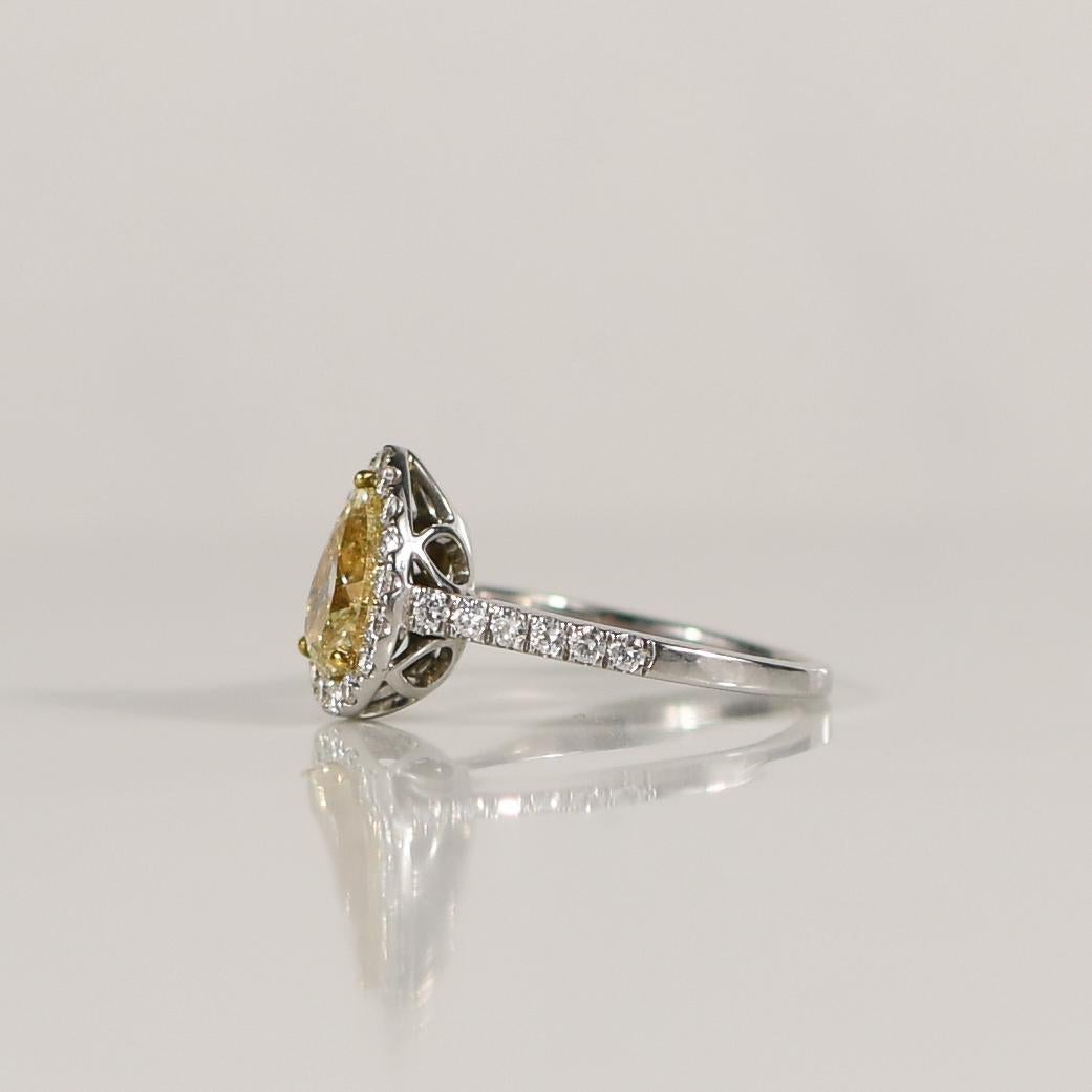 Celebrate the union of modern elegance and timeless beauty with this captivating engagement ring, featuring a dazzling 1.57 carat fancy light yellow pear-cut diamond as its focal point. The unique pear shape exudes sophistication and individuality,