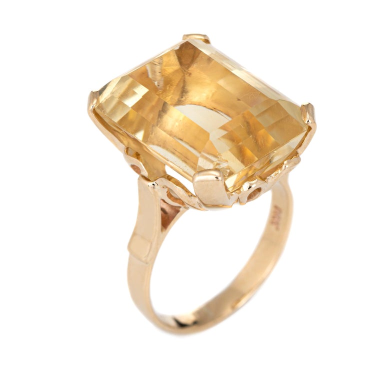 Stylish vintage lemon citrine cocktail ring (circa 1950s to 1960s) crafted in 14 karat yellow gold. 

Emerald cut lemon citrine measures 18mm x 13.5mm (estimated at 20 carats) The citrine is in excellent condition and free of cracks or chips. 

The