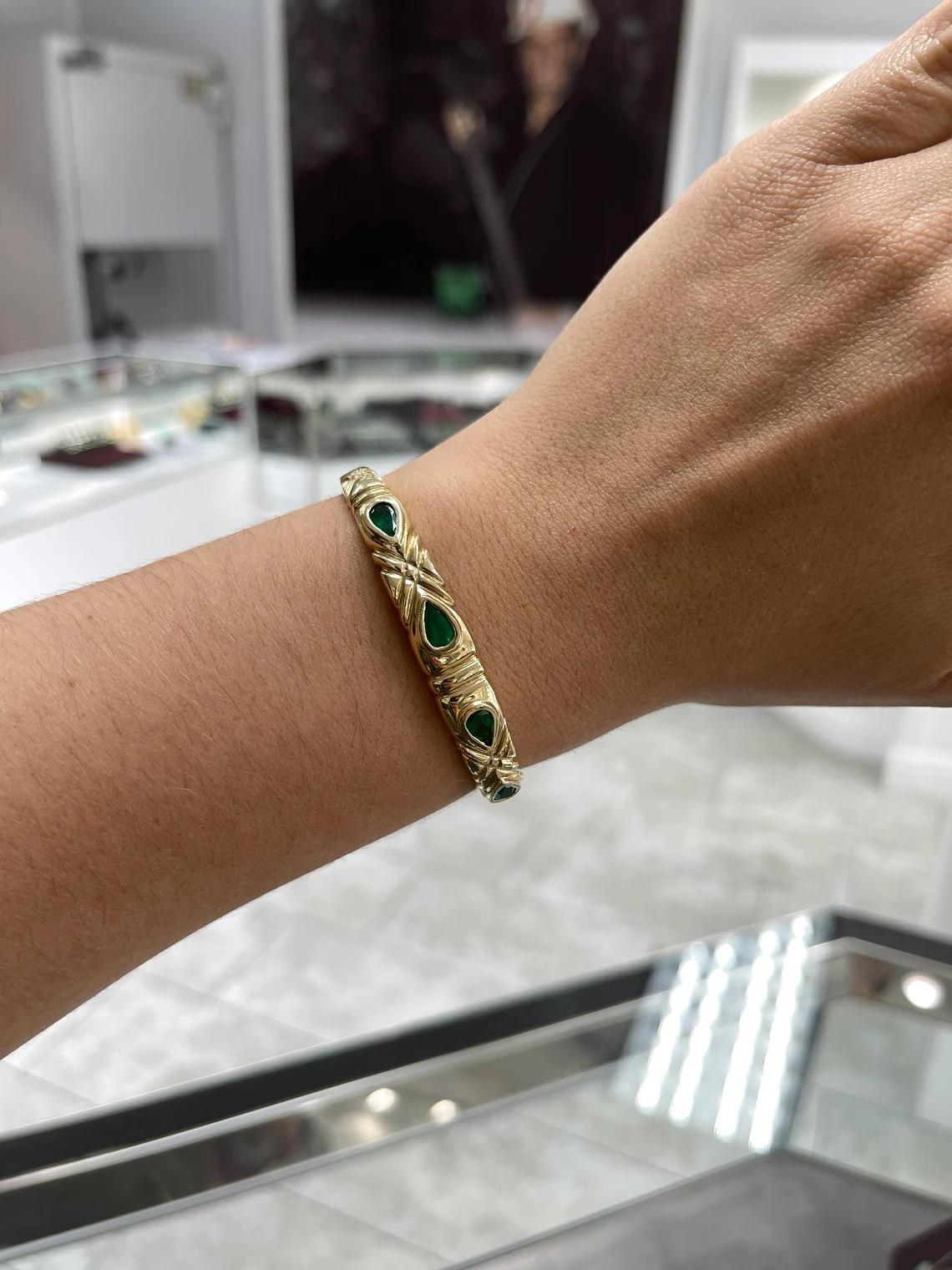 Bracelet Style: Bangle
Bracelet Length: 7 inches
Bracelet Width: 9.30mm

Setting Style: Bezel
Setting Material: 14K Yellow Gold
Setting Weight: 19.01 Grams

Main Stone: Emerald
Shape: Pear Cut
Weight: 2.0-Carats (Total)
Clarity: Transparent
Color: