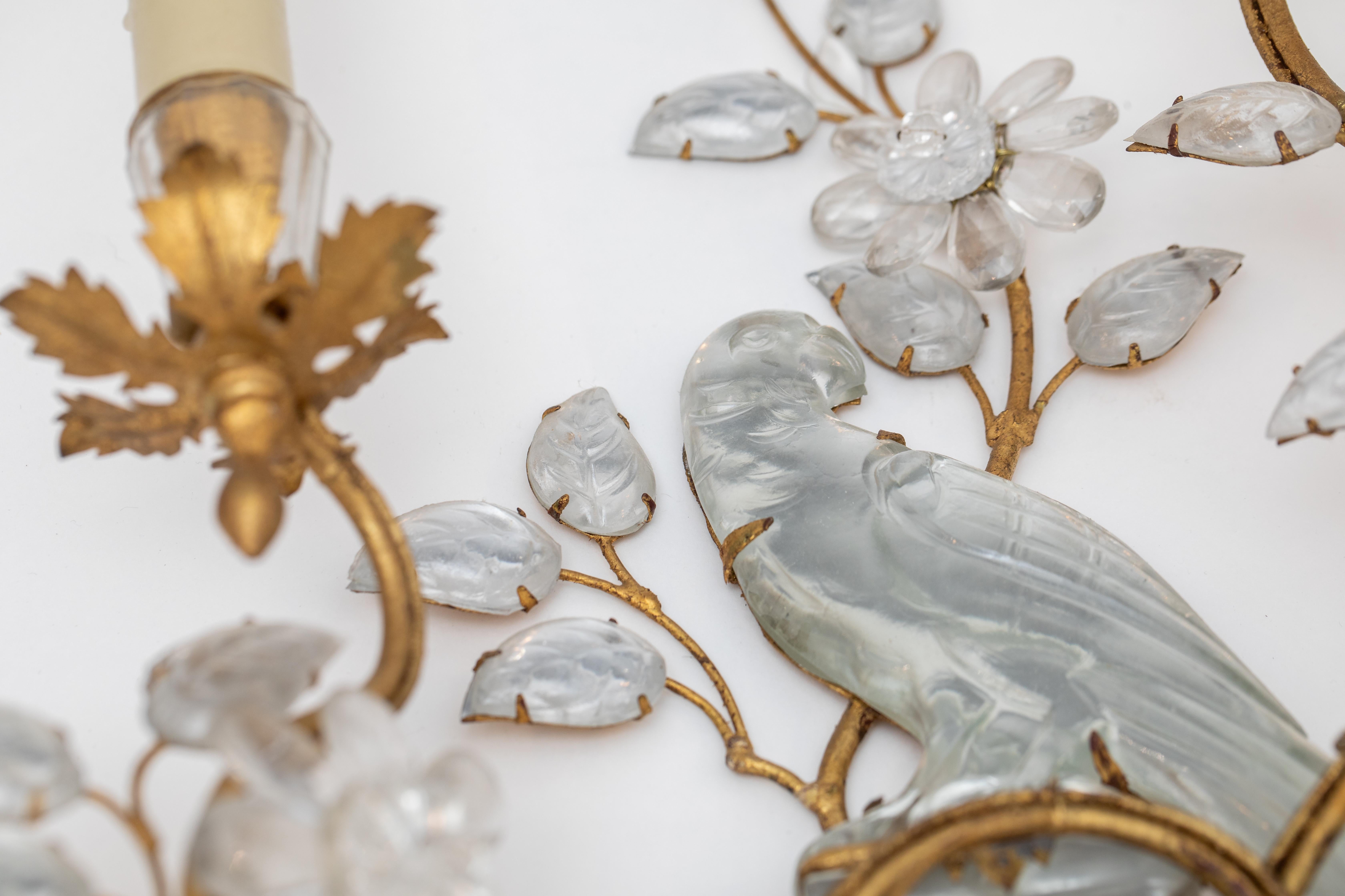 Paar Wandleuchter von Maison Bagues` Paris, Frankreich , aus vergoldetem Eisen und Kristall mit Papageien.
Die schönen und besonderen Wandleuchter befinden sich in einem sehr guten Zustand, wurden wohl in den achtziger Jahren angeschafft.  