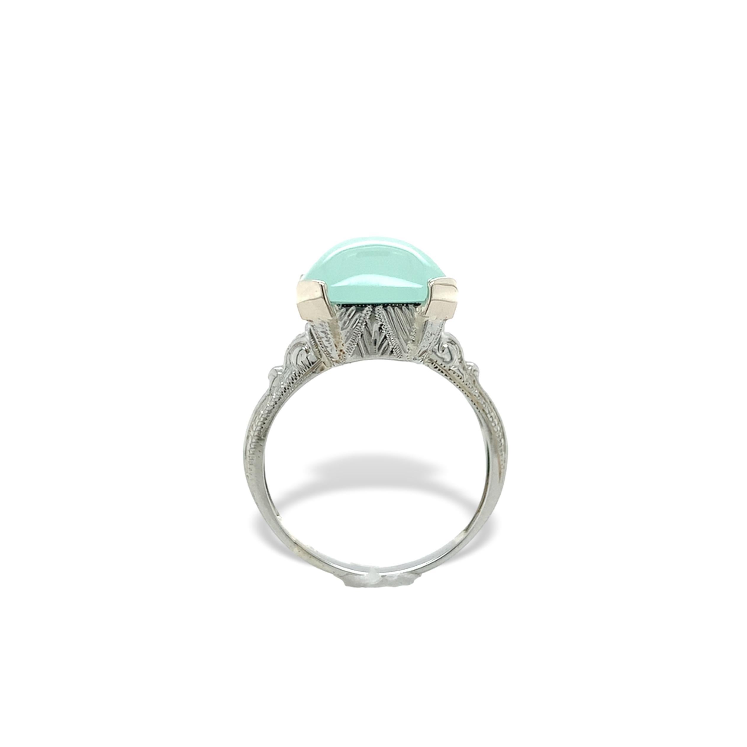 20K white gold ring featuring a 4.05 carat aquaprase. The rectangular cabochon cut chalcedony is a light mint green color and measures about 12mm x 10mm. The ring fits a size 4.5 and weighs 2.10dwt. It is a vintage 1940's hand engraved ring fully