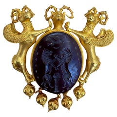 Spilla in oro giallo 20K con corniola intagliata e motivo ariete con gocce granulari