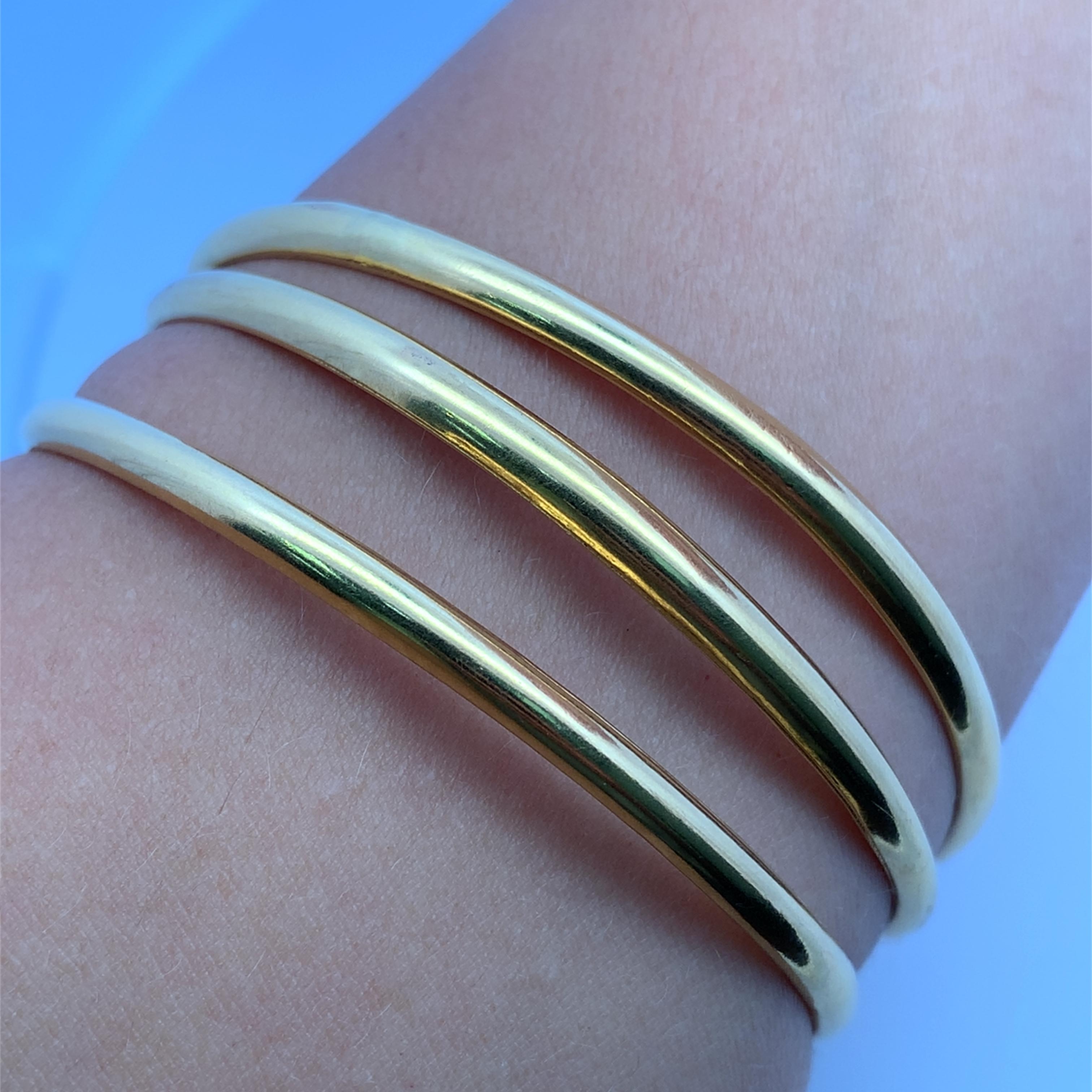 Elevate your style with this classic 20k yellow gold bangle. Crafted from lustrous 20k yellow gold, this bangle boasts a sleek, minimalist design that exudes timeless elegance. Perfect for stacking or wearing alone, this piece will add a touch of