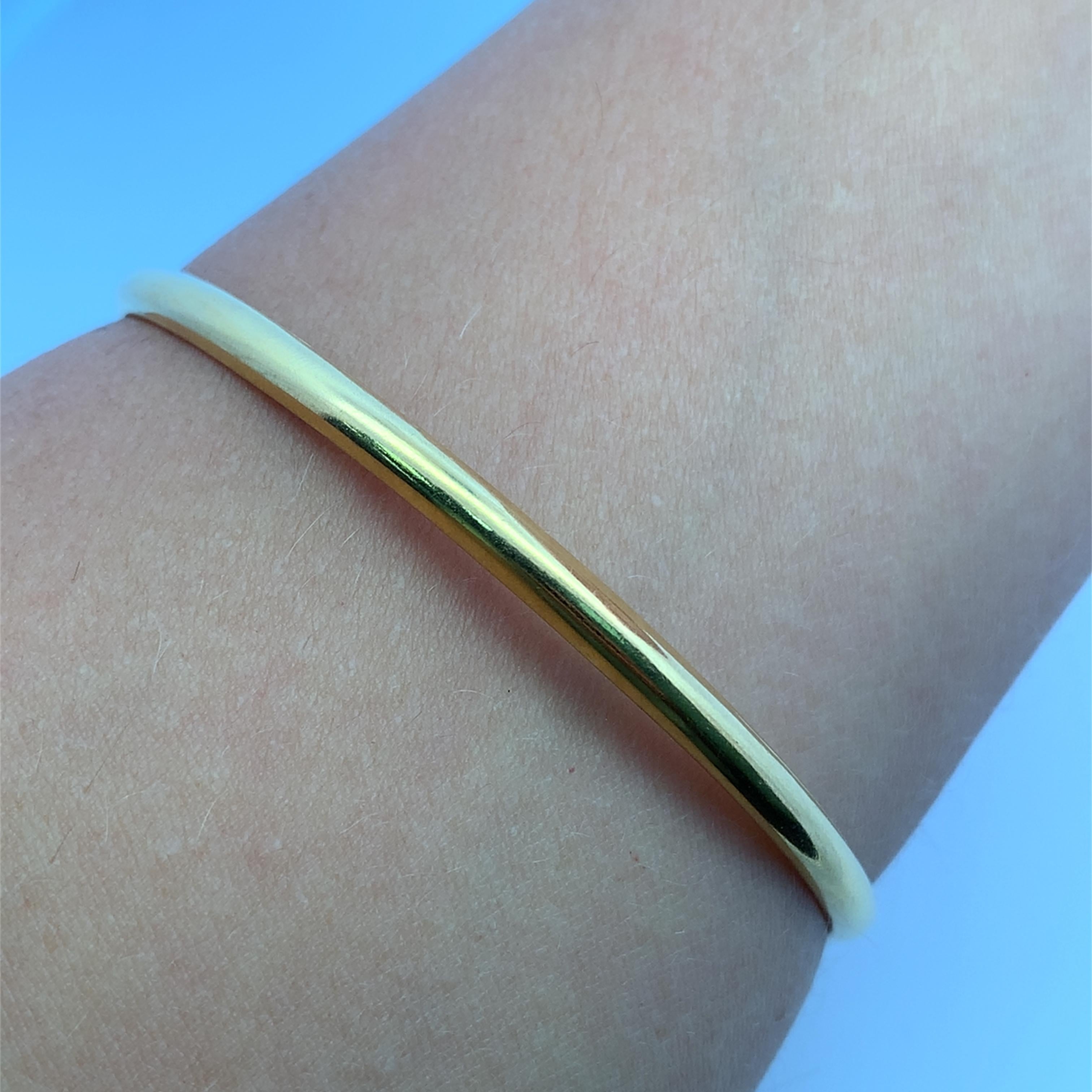 Elevate your style with this classic 20k yellow gold bangle. Crafted from lustrous gold, this bangle boasts a sleek, minimalist design that exudes timeless elegance. Perfect for stacking or wearing alone, this piece will add a touch of understated