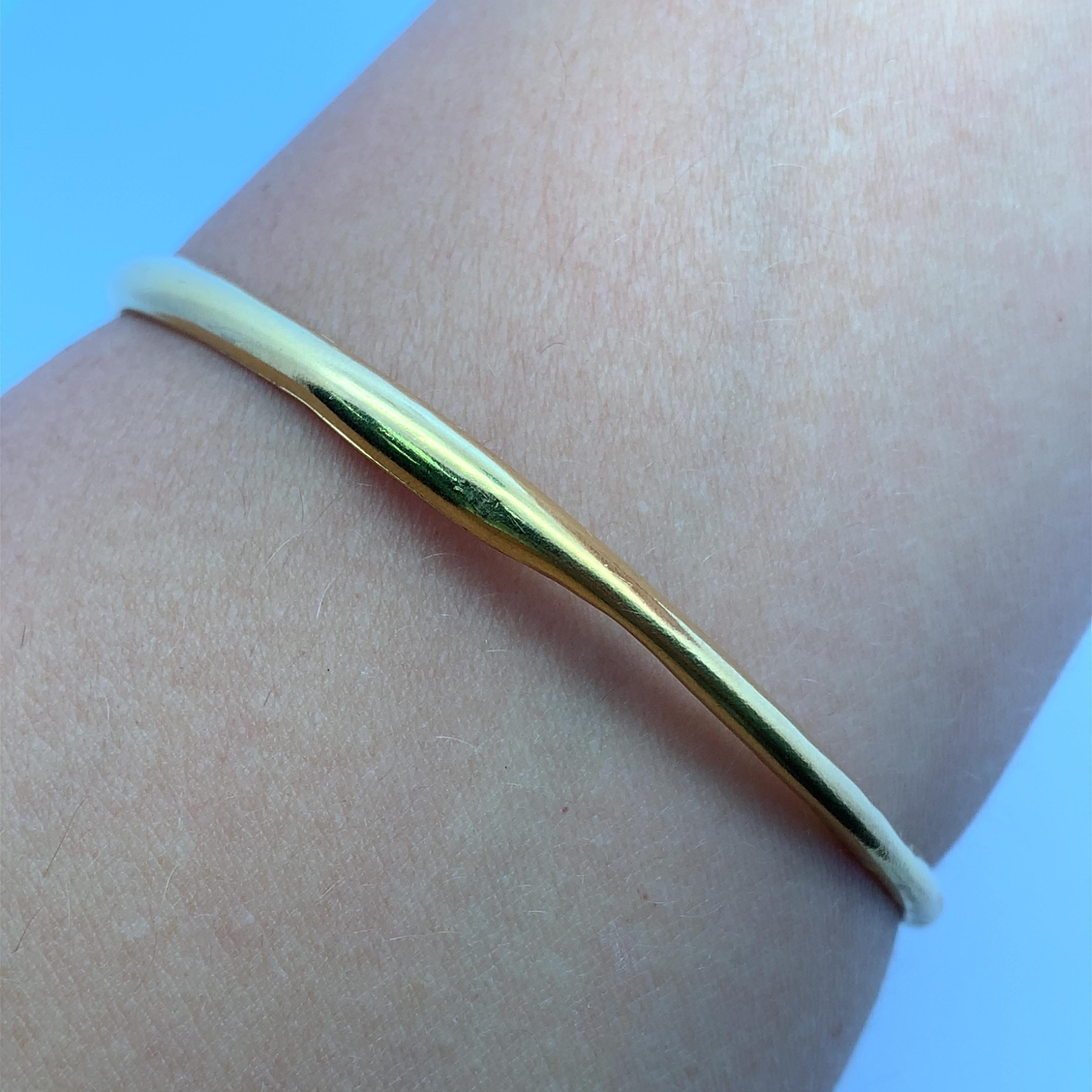 Elevate your style with this classic 20k yellow gold bangle. Crafted from lustrous gold, this bangle boasts a sleek, minimalist design that exudes timeless elegance. Perfect for stacking or wearing alone, this piece will add a touch of understated