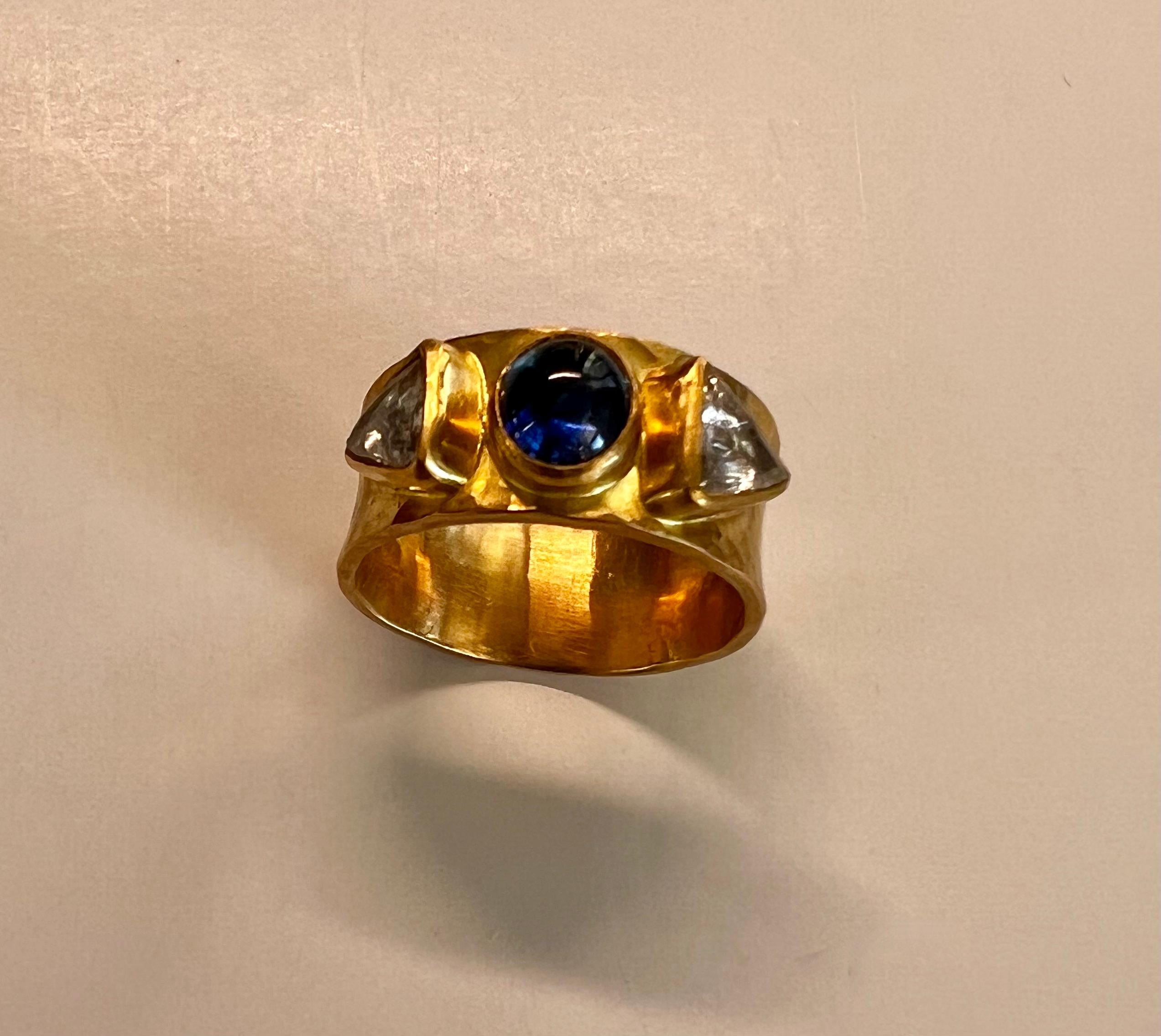 Bague 20 et 22 carats avec cabochon ovale en saphir bleu et anneau en diamants Macle, sertis dans un anneau martelé.
Un Macle est une forme cristalline, un cristal jumeau ou un cristal double comme on en voit dans les cristaux octaédriques (8) ou