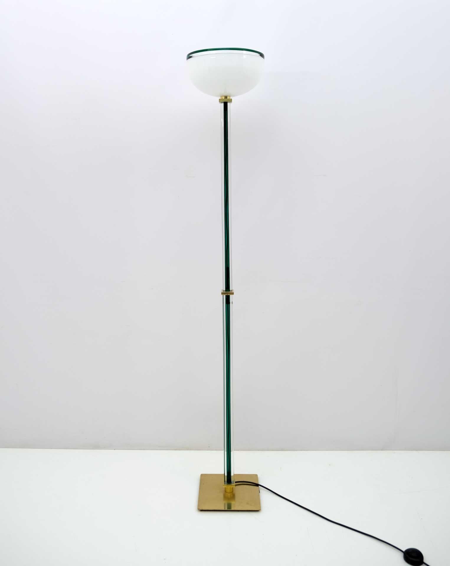 Floor lamp in blown and handmade glass, produced and signed by Venini. Lattimo diffuser, stem and decoration in crystal with green core. Base and supports in brass.