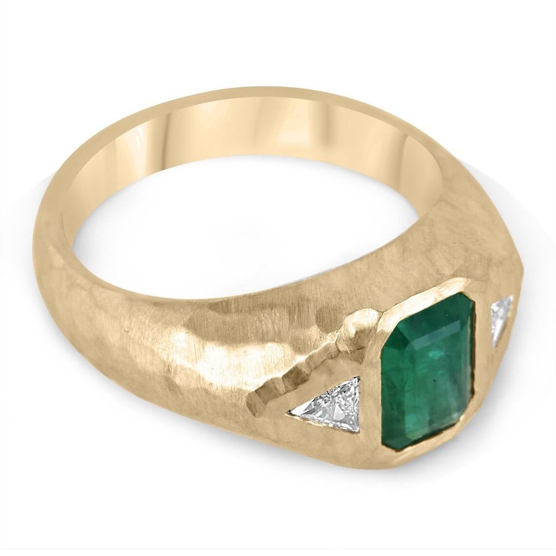 This exquisite three stone ring features a fine quality Zambian emerald as its center stone, bezel set vertically for a modern and sophisticated look. Two trillion cut diamonds are set on either side of the emerald, adding a touch of sparkle and