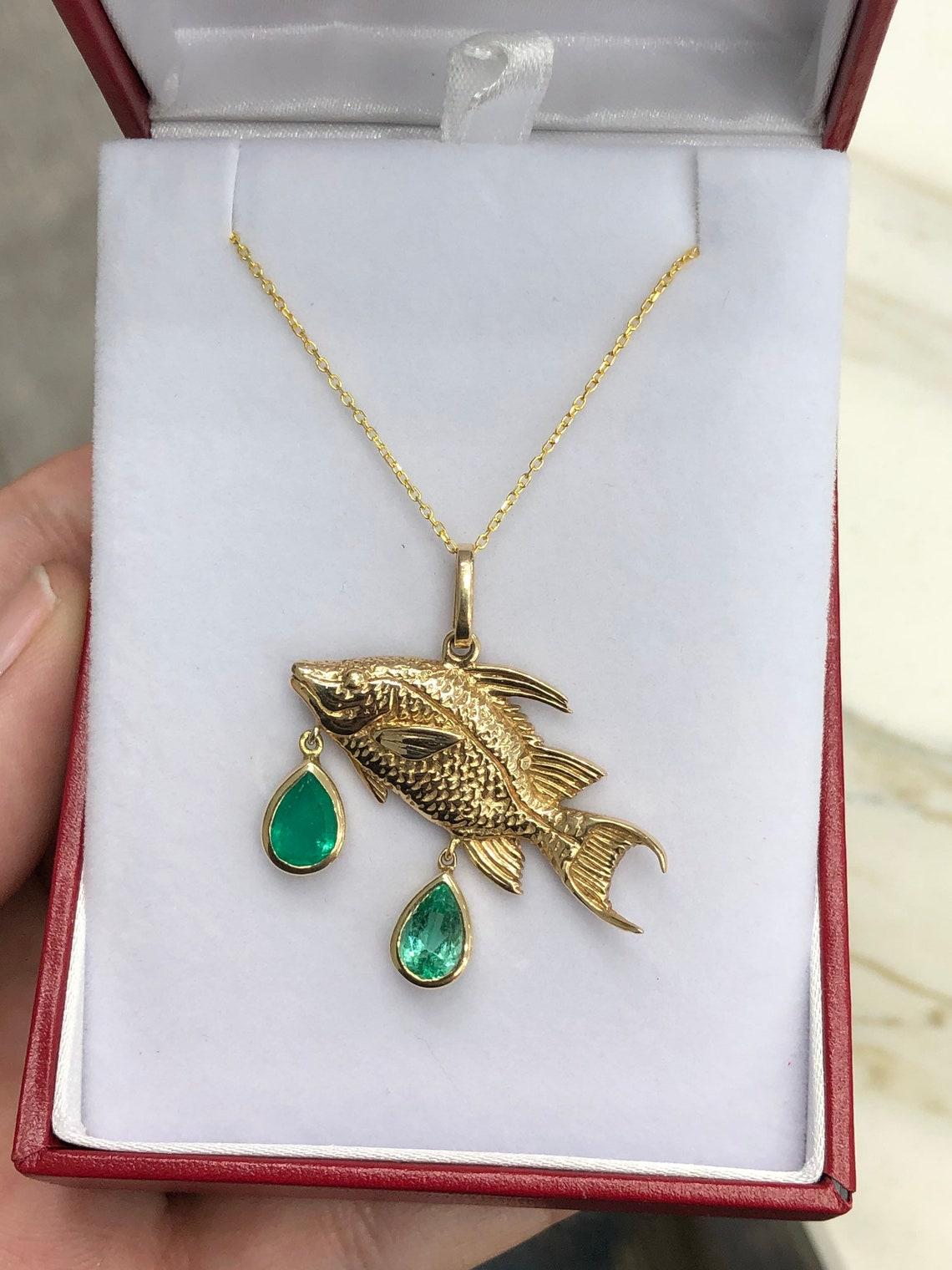 Un cadeau idéal pour les amoureux de l'océan ! Ce pendentif unique, en forme de vivaneau rouge émeraude de Colombie, est stupéfiant. Cette pièce mesure 1,45 pouce de long et 1,30 pouce de large, ce qui est impressionnant. La pièce est rehaussée de