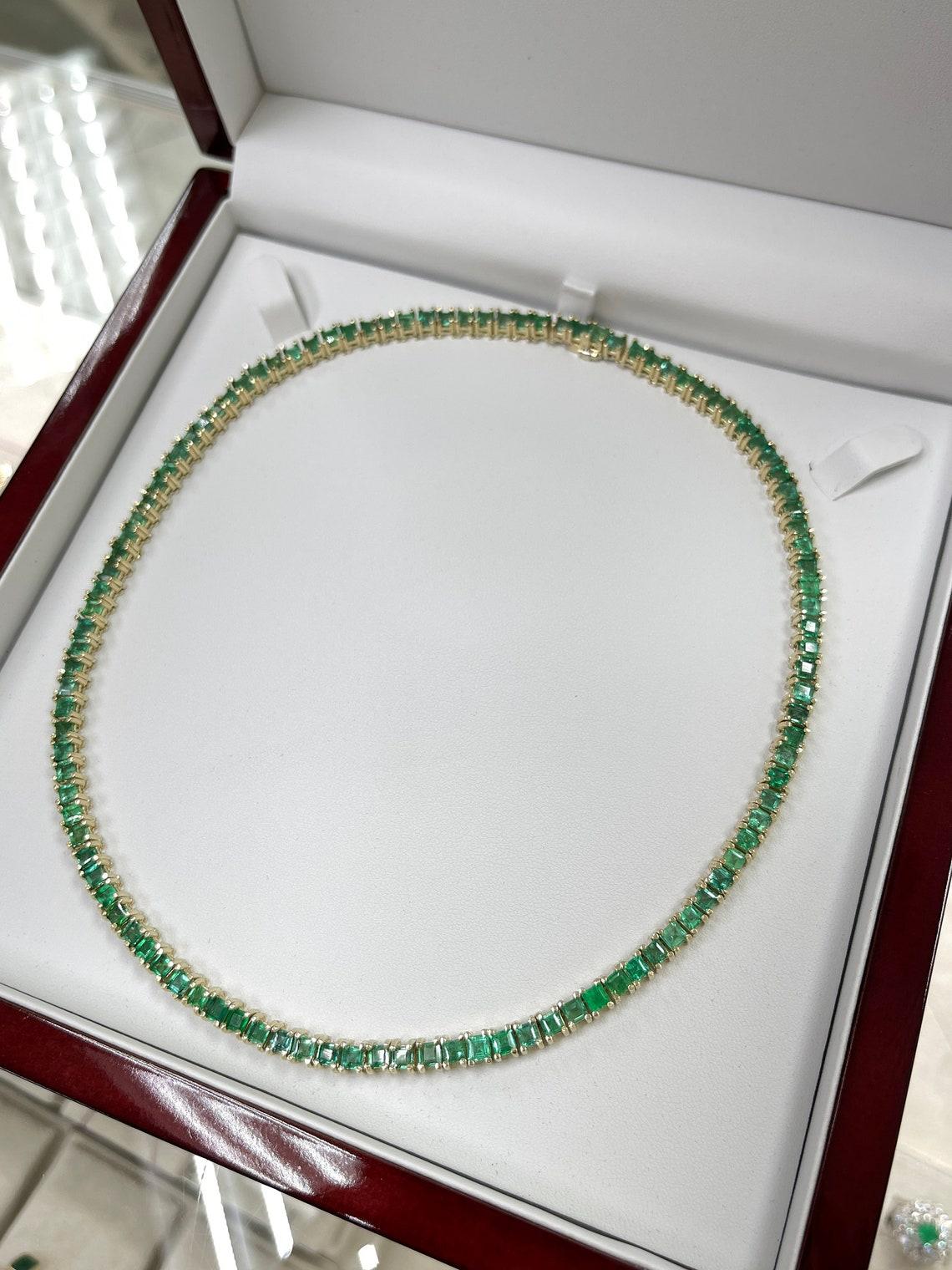 Indulge in opulent allure with our Emerald Tennis Necklace. Boasting over 20 carats of resplendent green princess cut emeralds, each gem exquisitely showcased in prong baskets, this necklace offers a radiant and regal touch. Customizable in length