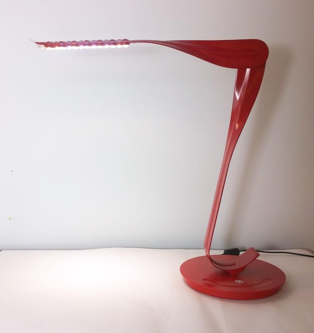 Offered is a signed later 20th century modern early 21st century Minimalist Herman Miller LED leaf desk lamp in cherry red by Yves Behar. This fantastic piece has so many adjustable positions, it is too many to count. The LED lighting also has