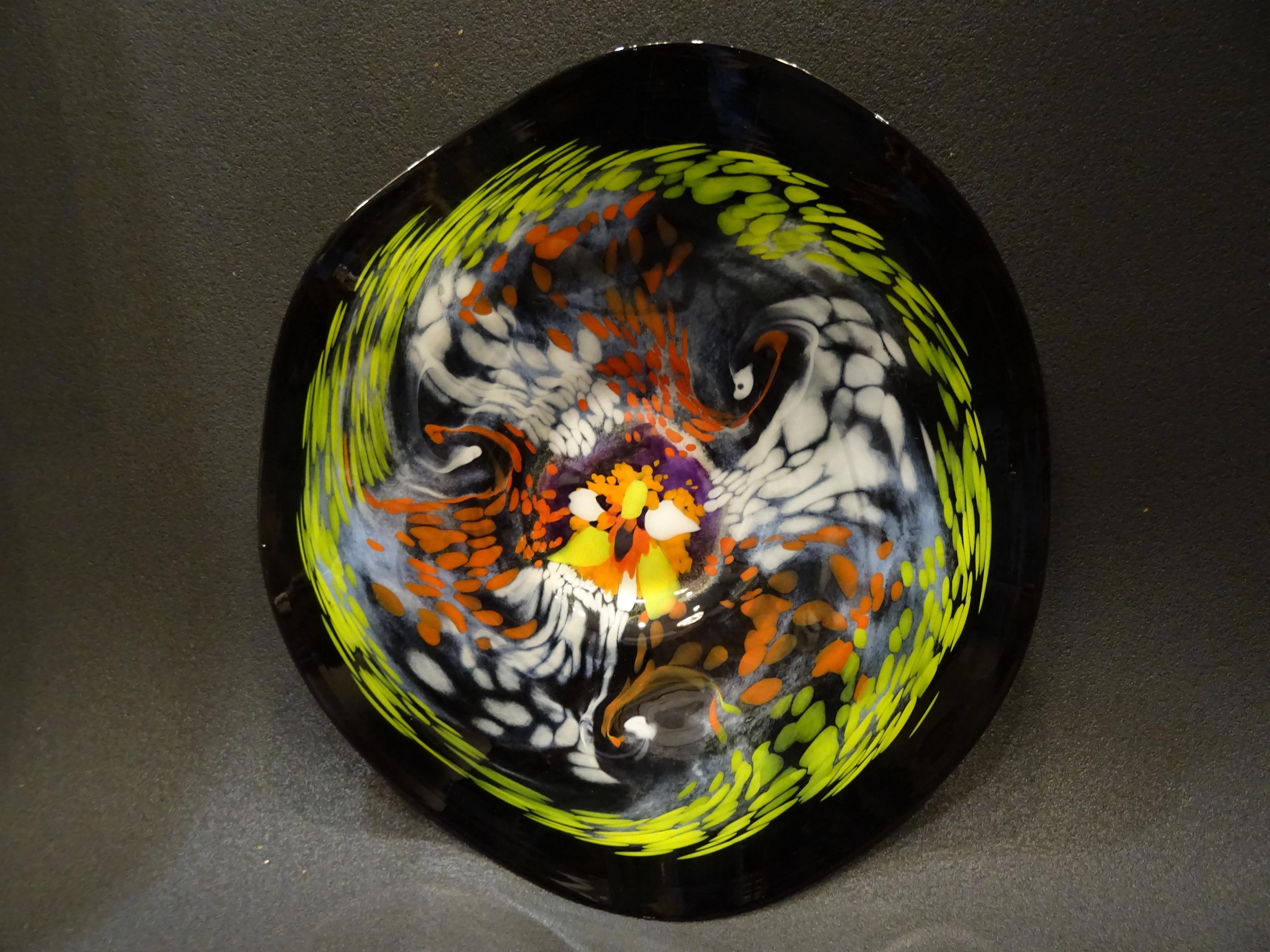Unique and very refined piece of glass, blown glass, 20th century. A large black dish, with a psicoledic design in different colors, orange, green, yellow, blue and white. It’s a craft made piece. On the back it makes another amazing design in black