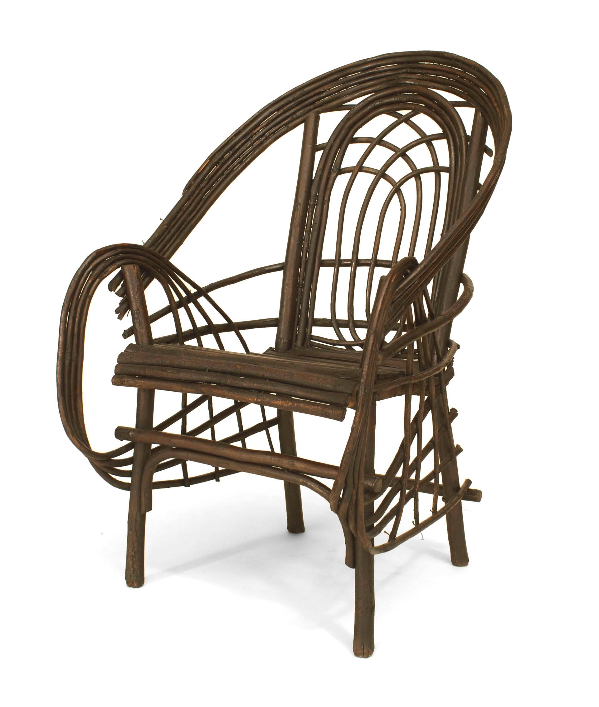 Rustic Adirondack (20th Cent) willow twig design arm chair with a barrel
shaped back and circle design on front of the arms and a slat seat.
