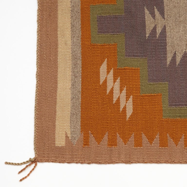 20th c., saddle blanket from the American Southwest. Green, grey and brown woven wool, with a double stepped diamond medallion in the center on a brown ground, solid striped and sawtooth borders. Lazy lines, a wool warp and side selvage cord are all
