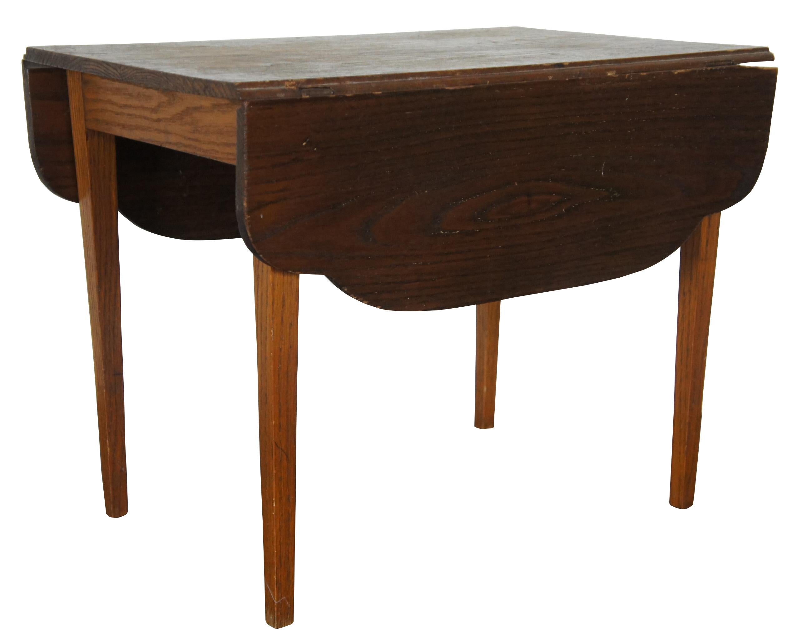 Early 20th century miniature drop-leaf table. Shaker style with tapered legs and a serpentine drop leaf. Made from pine.