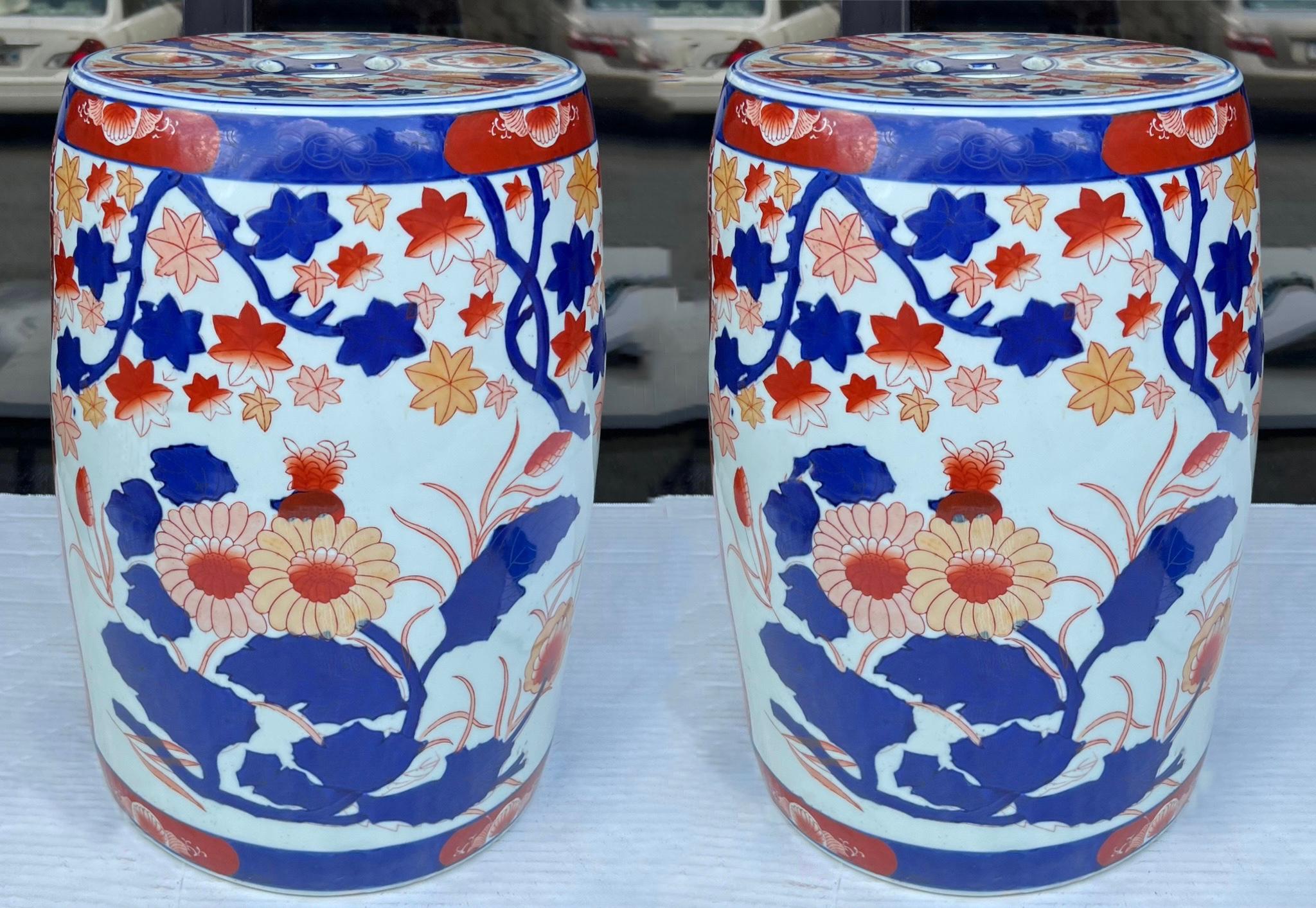 These are lovely. They are a pair of late 20th century Imari or Chinese Export style garden seats or side tables. They have vibrant hand painted blue and Orange hues on a white background. They are in very good condition.