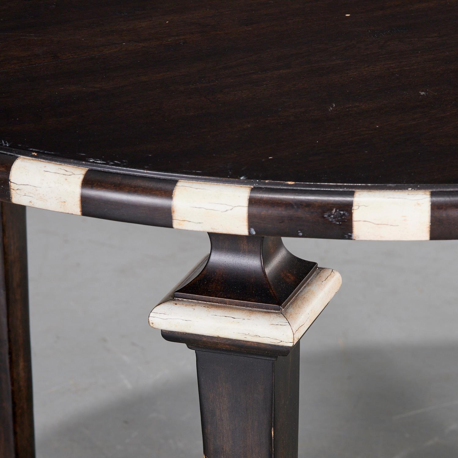 20th c., USA, a custom painted Minton-Spidell Georgetown Center Table.

The table features a round wooden top with a striking black and cream checkerboard-patterned edge. The wood is finished in a dark, rich tone.
The table top rests on four