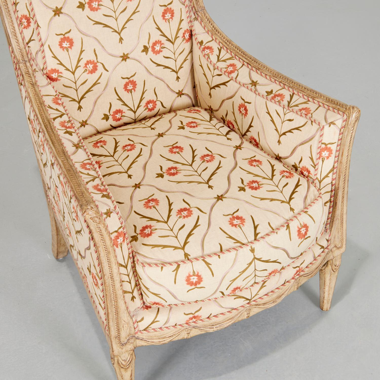 Mid 20th C. Directoire style crewelwork bergere with a cream painted wood frame decorated with bands of carved rope and draped swags. The crewelwork upholstery is accented with a complementary silk rope trim, while the back of the chair is