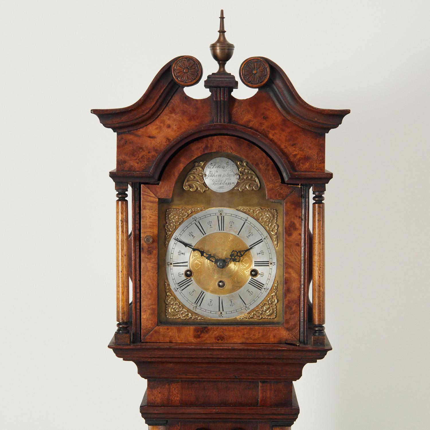 20th c., London, a grandmother clock in a wood case with mixed veneers, with scrolled open pediment top, hinged door opens to brass and silverplate Roman numeral dial, face marked 