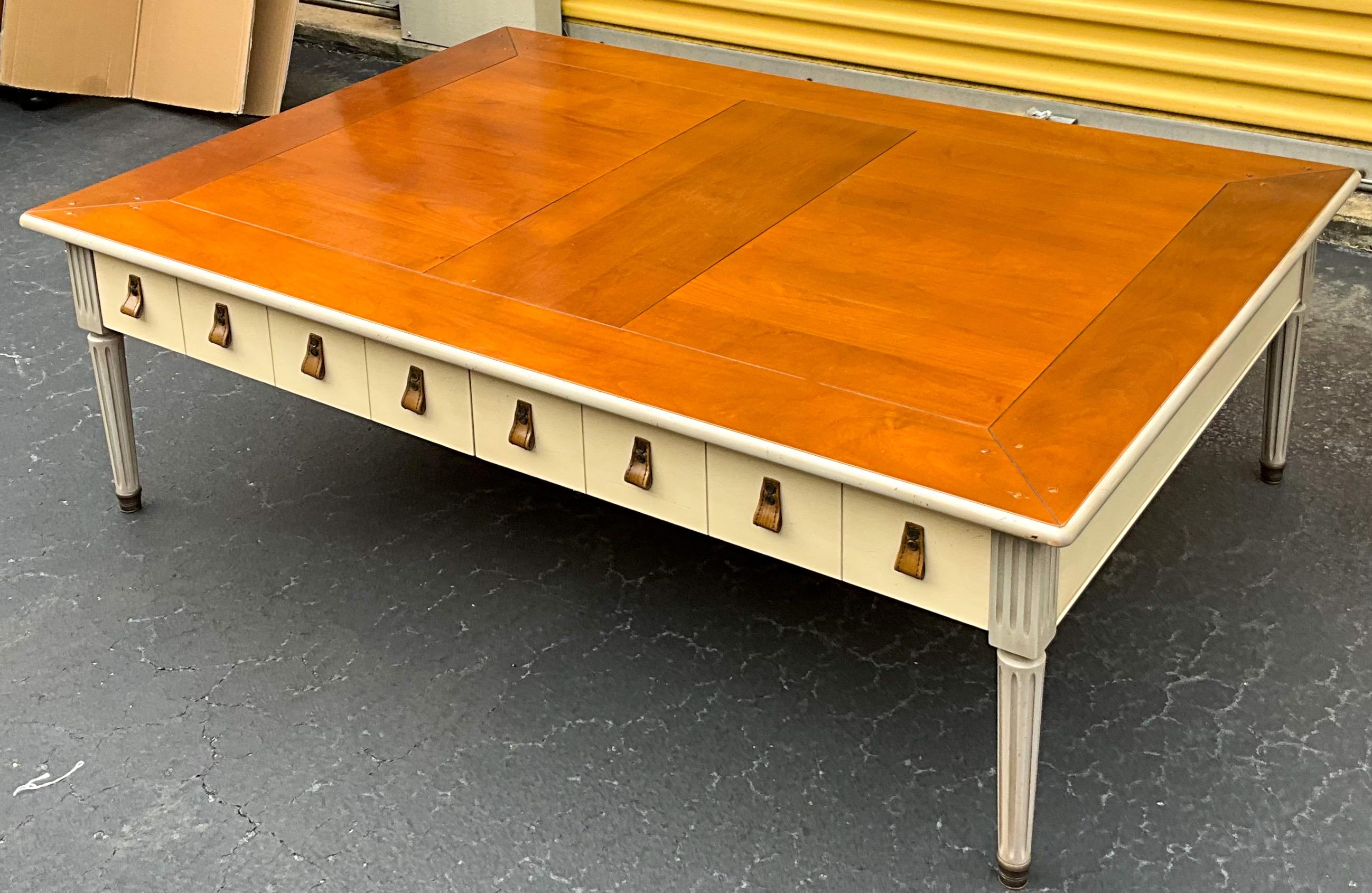 This is a late 20th century French gray painted coffee table with Swedish styling by Grange. The piece is so unique! The top appears to be cherry, and the painted legs and apron are in a French gray and ivory. My favorite feature is the partner