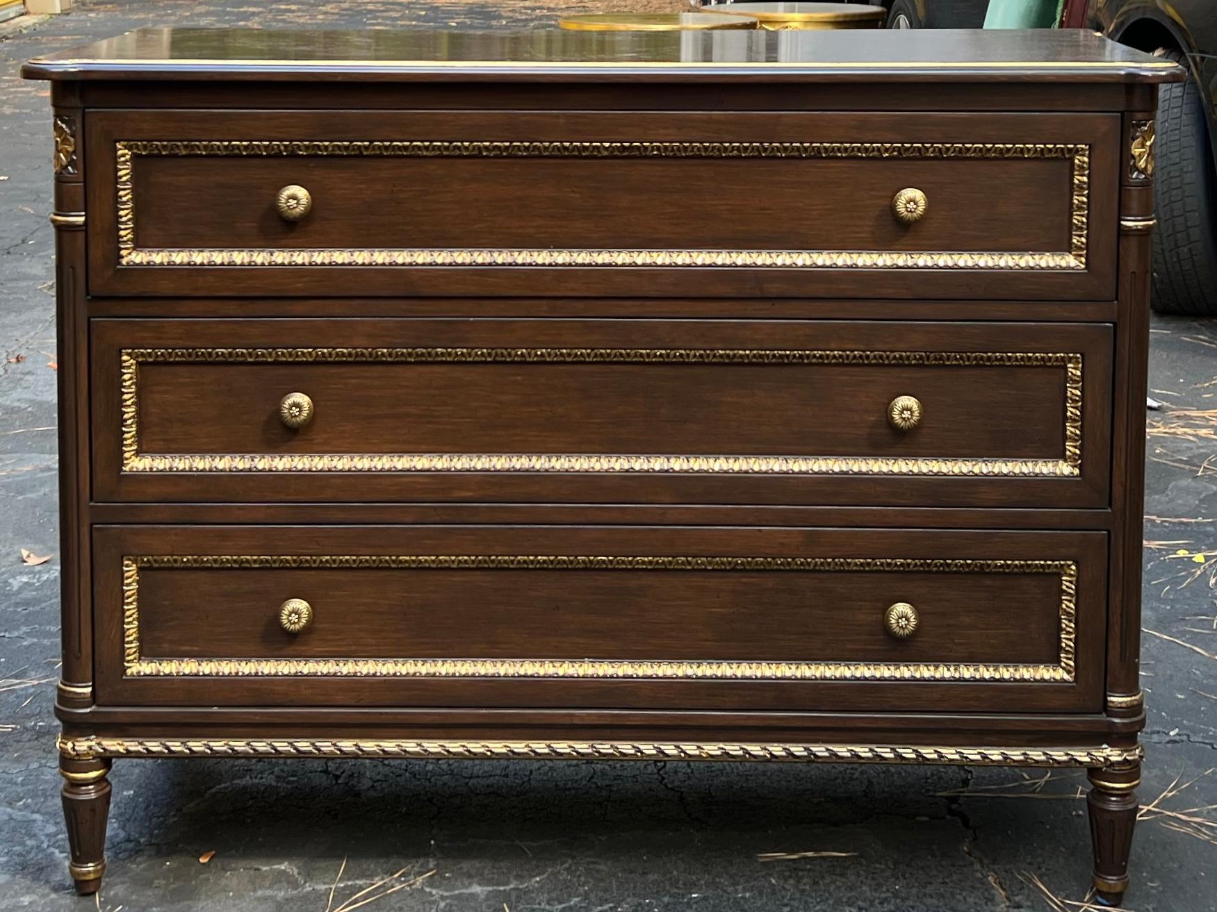 This is a pair of Louis XVI style chests or commodes in very good condition. They are cherry with gilt accents. They date to the later part of the 20th century and were manufactured in America.