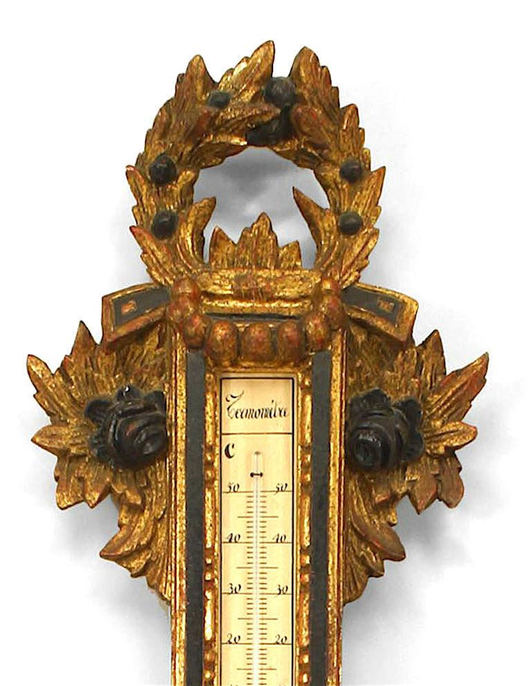 Italian Venetian-style (20th Century) gilt carved and black painted barometer,with wreath top and cornucopia sides with scroll motifs.
