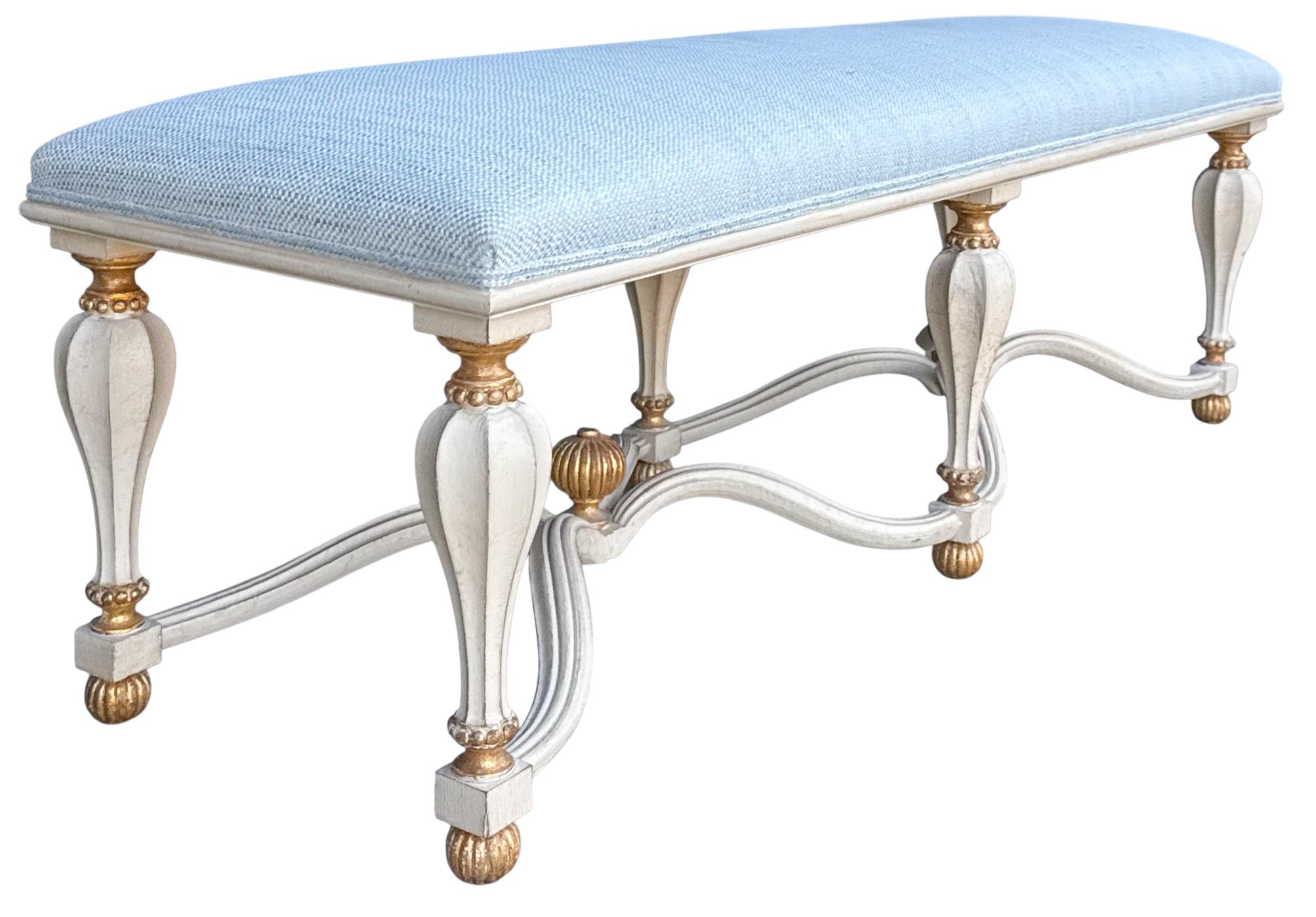 This is a lovely Italian hand carved bench. The frame is a sort of a white wash with carved gilt accents. The blue upholstery has somewhat of a texture to it. It is in very good condition. It is marked on the underside, “ Made in Italy”. 