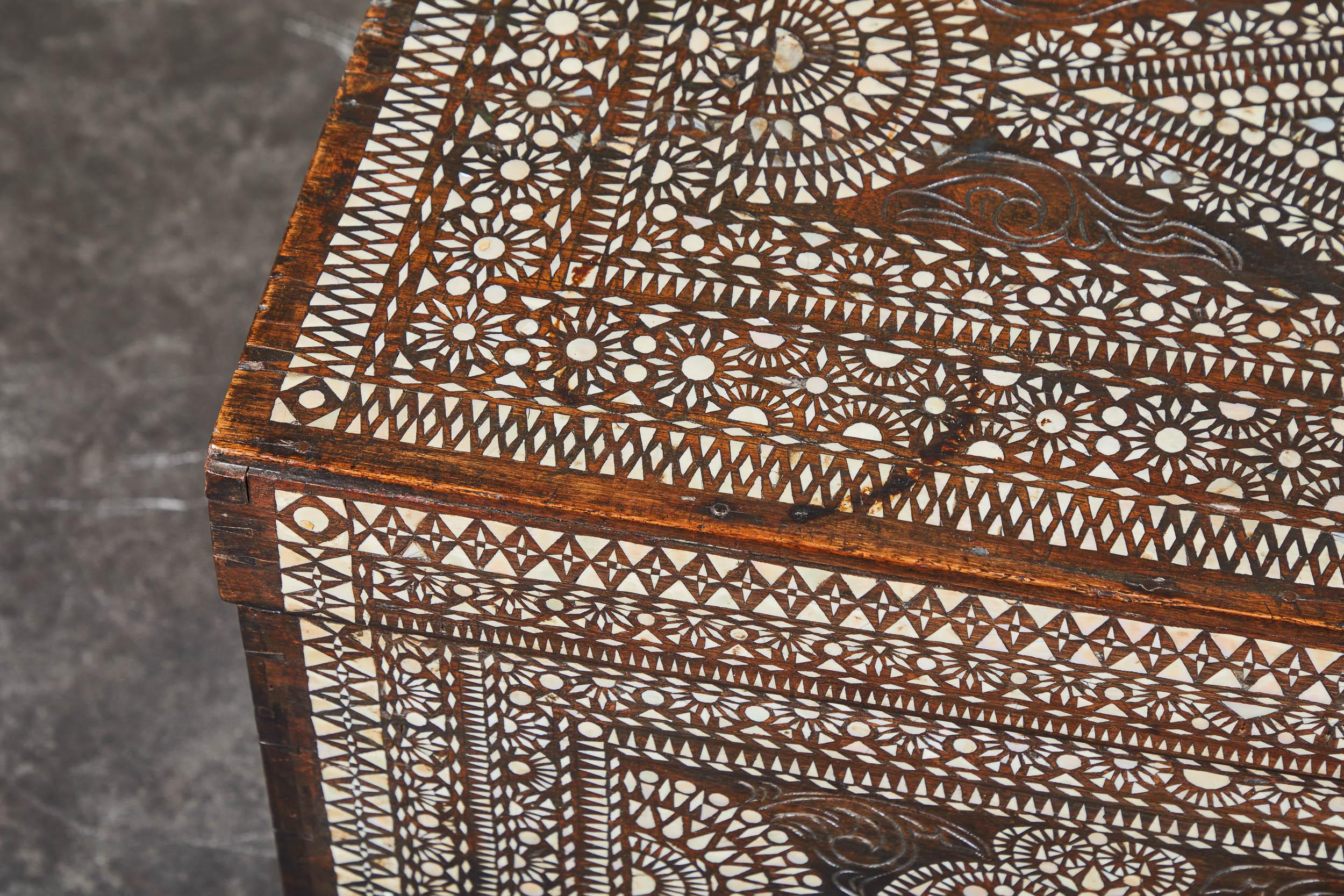 A dark-wood 20th century heavily-inlaid trunk of Filipino origin. Handles on either side and hinged top make it functional as occasional storage, as well.