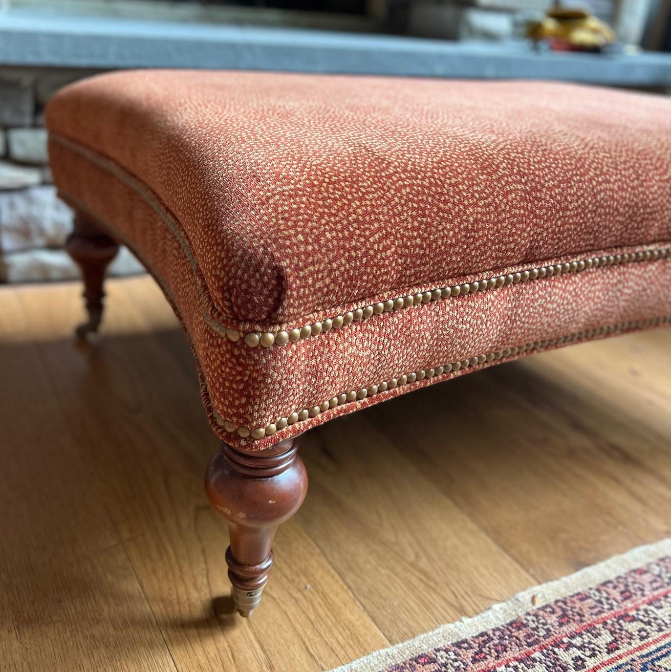 20e siècle, un tabouret de style Louis XVI avec des côtés concaves et un siège rectangulaire rembourré, reposant sur des pieds en bois tourné avec des roulettes en laiton. L'assise est recouverte d'un velours imprimé animalier de petite taille et de