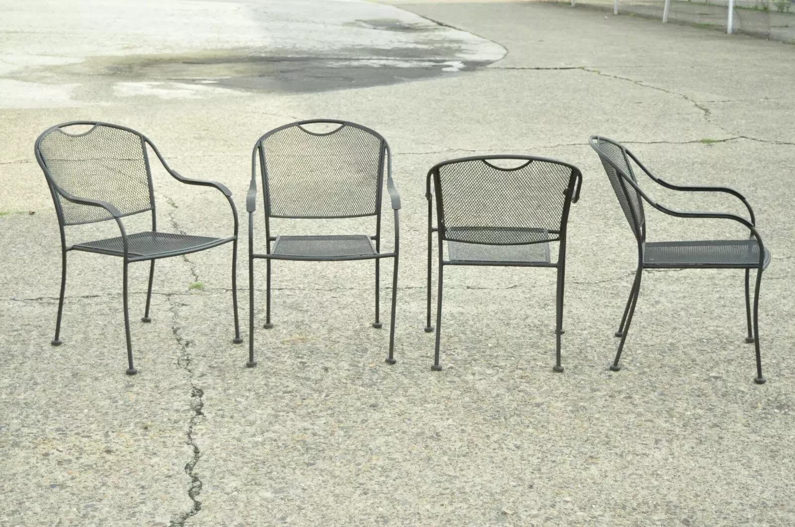 20th C Modern Wrought Iron Sculptural Black Outdoor Arm Chairs - Set of 4. Item features (4) armchairs, stacking frames, wrought iron construction, sleek sculptural form. Circa Mid 20th Century. Measurements: 33