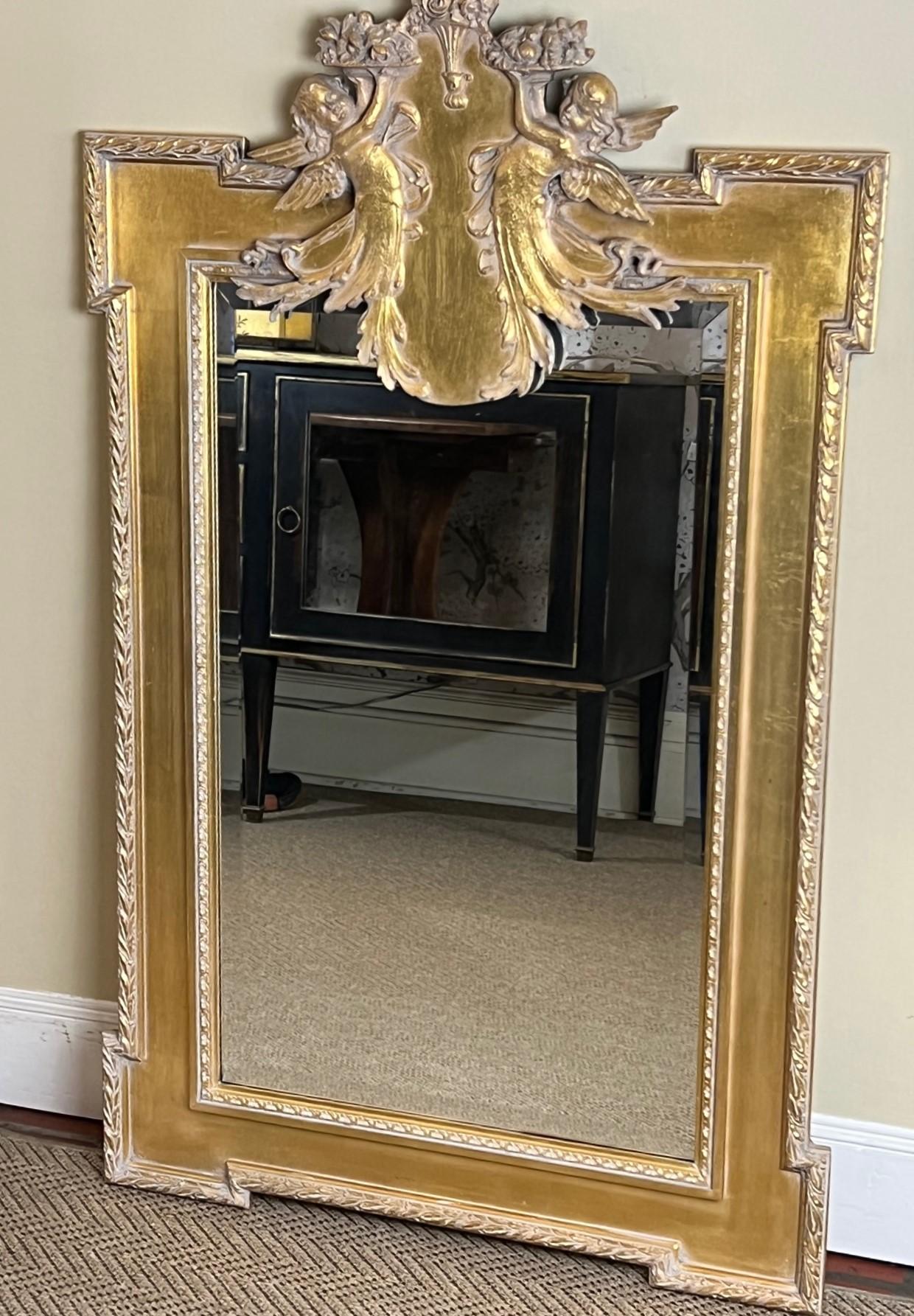 An attractive vintage pier/wall mirror that combines gilt-wood elements with the clean and refined lines championed in the neoclassical era. The carved frame features geometric patterns and motifs inspired by nature. The frame is simple and molded