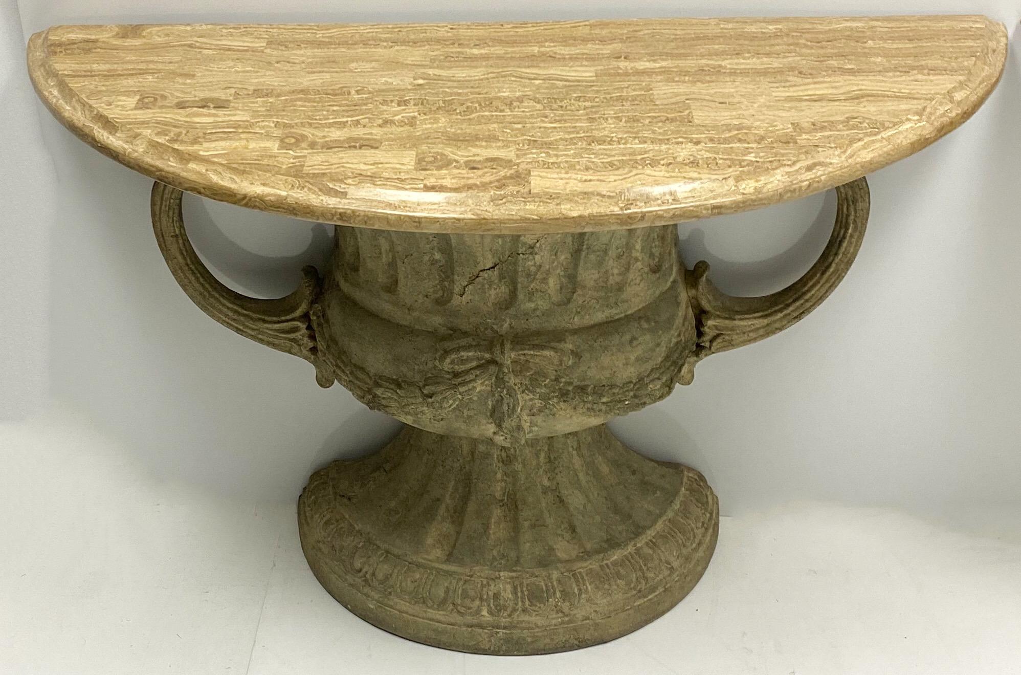 This is a pair of neoclassical style urn form console tables with attached tessellated marble tops. They have intentional distressing. The body is cast fiberglass. They are unmarked and in very good condition.