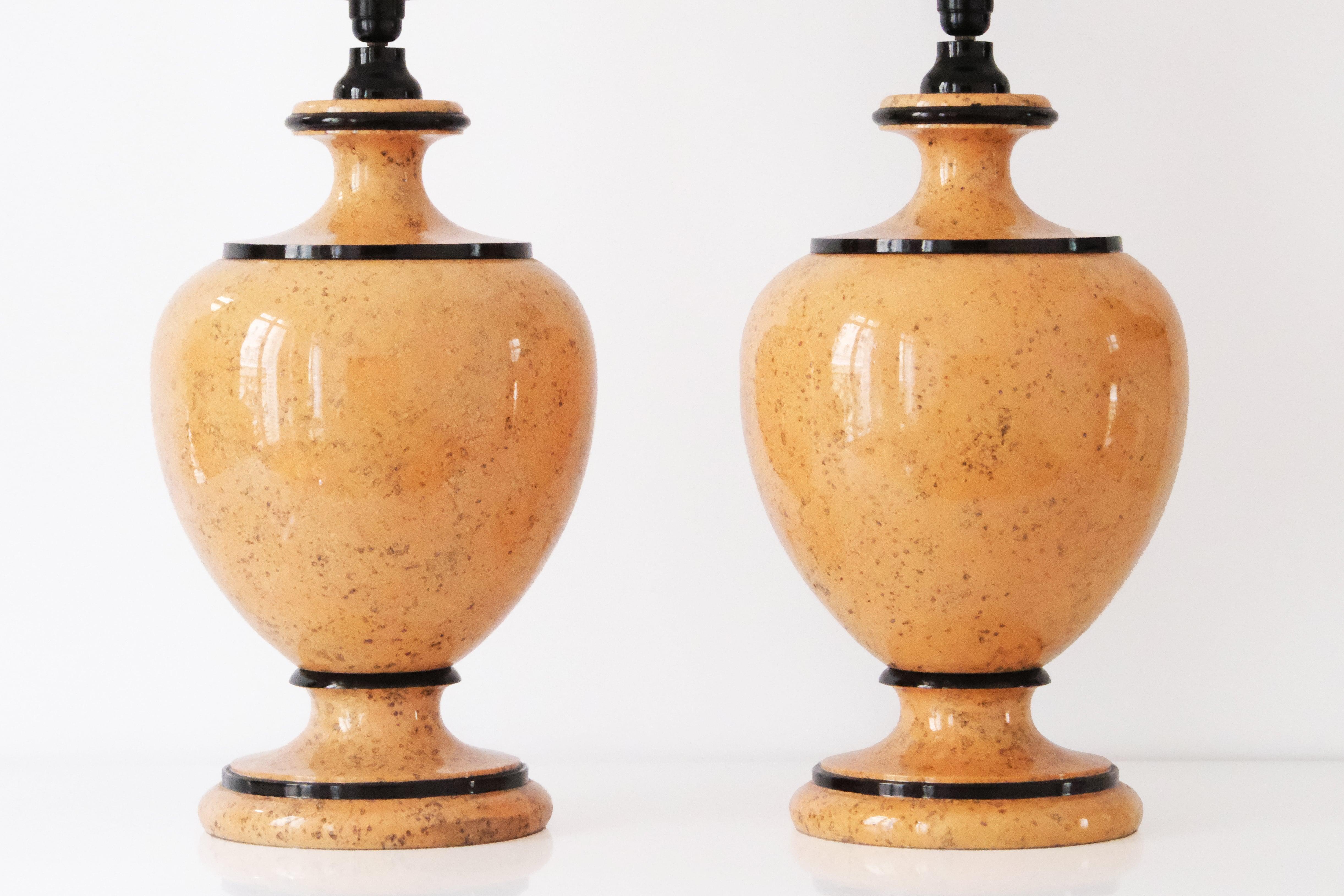 Una raffinata e rara coppia di lampade da tavolo di grandi dimensioni, ciascuna caratterizzata da una base a forma di balaustro splendidamente scolpita che poggia su un basamento circolare tornito. Realizzate con una pietra beige con sottili