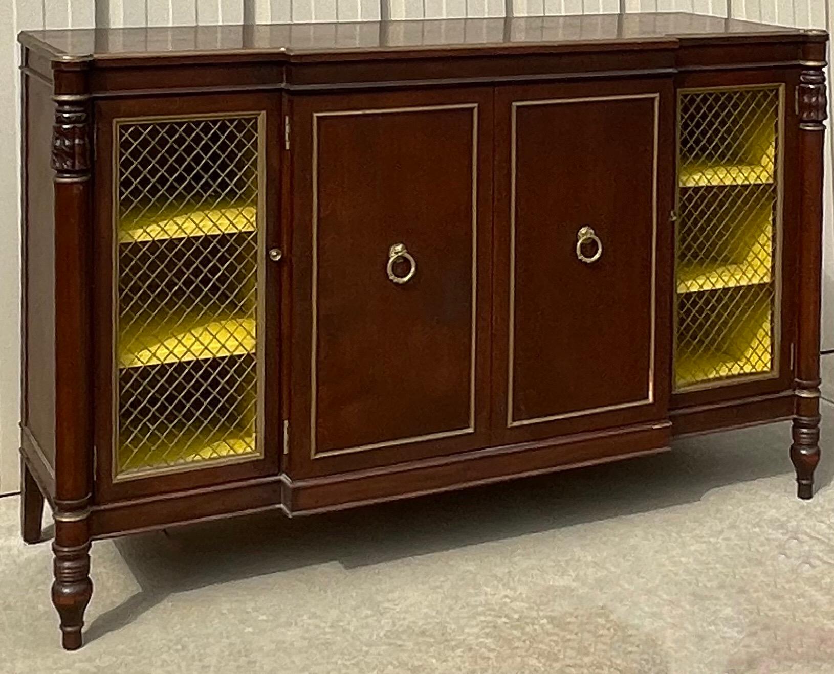 This is a lovely cabinet! It has Regency styling with a yellow painted interior. The doors have wire fronts that allow the interior to shine. It has interior shelves and drawer. It is unmarked and in very good condition.