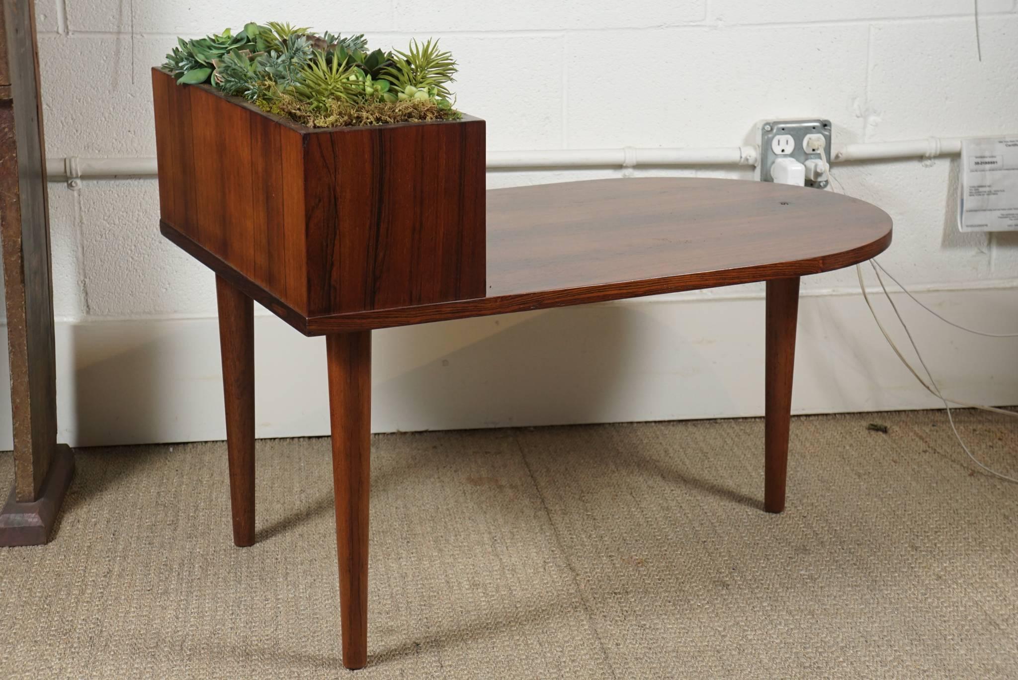 Here is a 20th century rosewood table with a zinc planter insert. The table has a tripod base and a curved front. The table has a new custom finish. The front shelf on the table is 17 inches high and the back is 24 inches high.