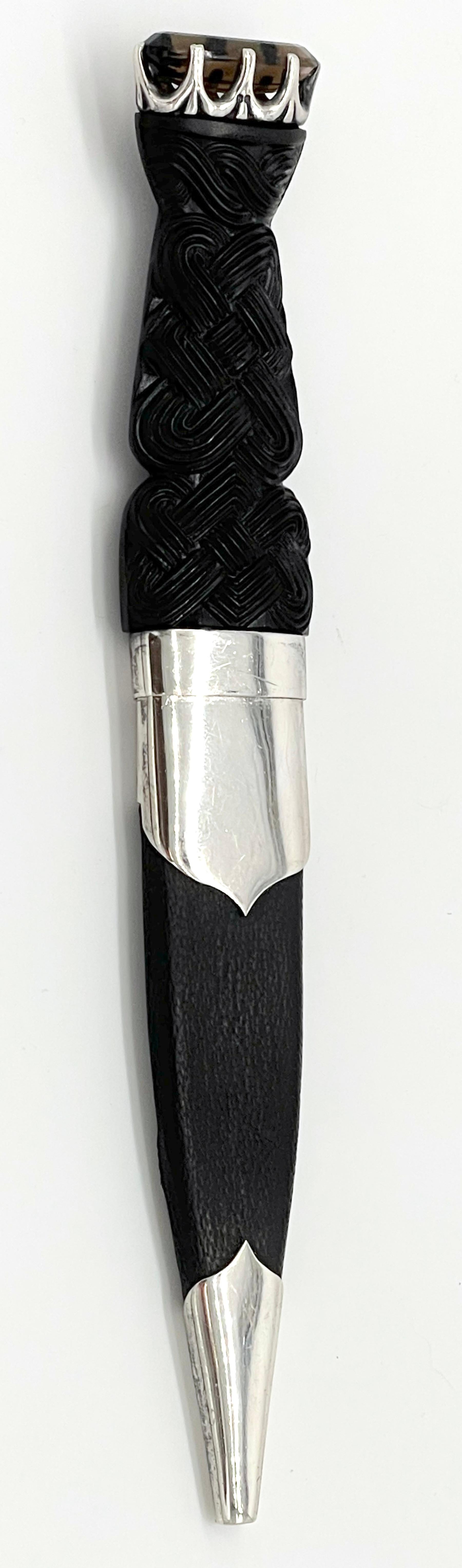20th Century Scottish Sterling & Carved Celtic Knot Bog Wood Dirk (Sgain Dubh) with Topaz, a stunning representation of traditional Scottish craftsmanship and design.

The dirk features an oval Topaz gemstone elegantly fitted at the top, adding a