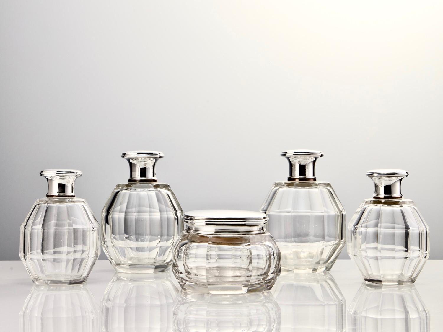 Presenting an superb 20th-century set of Art Deco French silver dressing table perfume bottles, originating around 1920.

This set captures the iconic Art Deco style with a stunning blend of faceted glass and fine quality silver. Crafted with