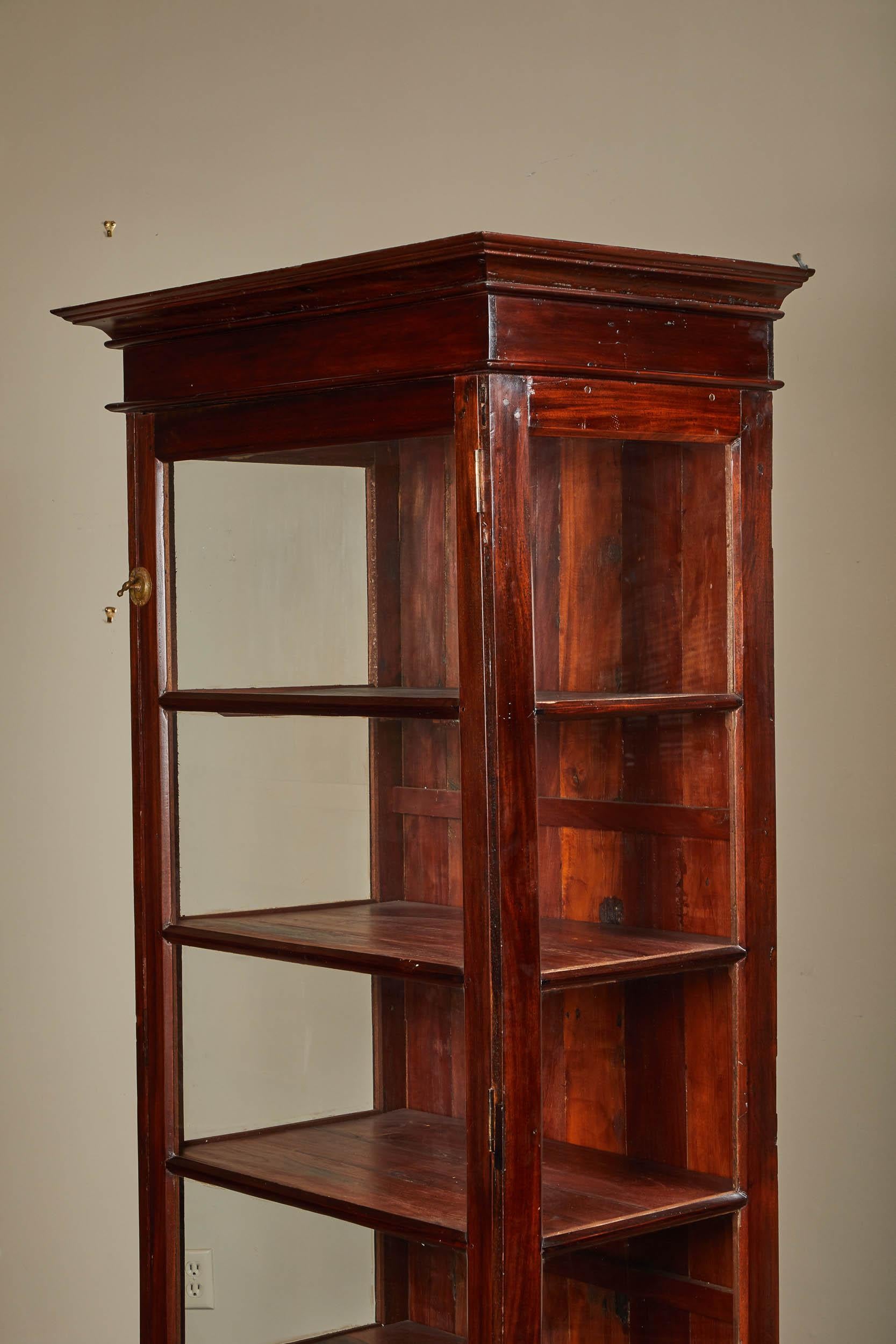 Mid-20th century Sri Lankan cabinet with three glass sides and a solid back. One single door with two latches.