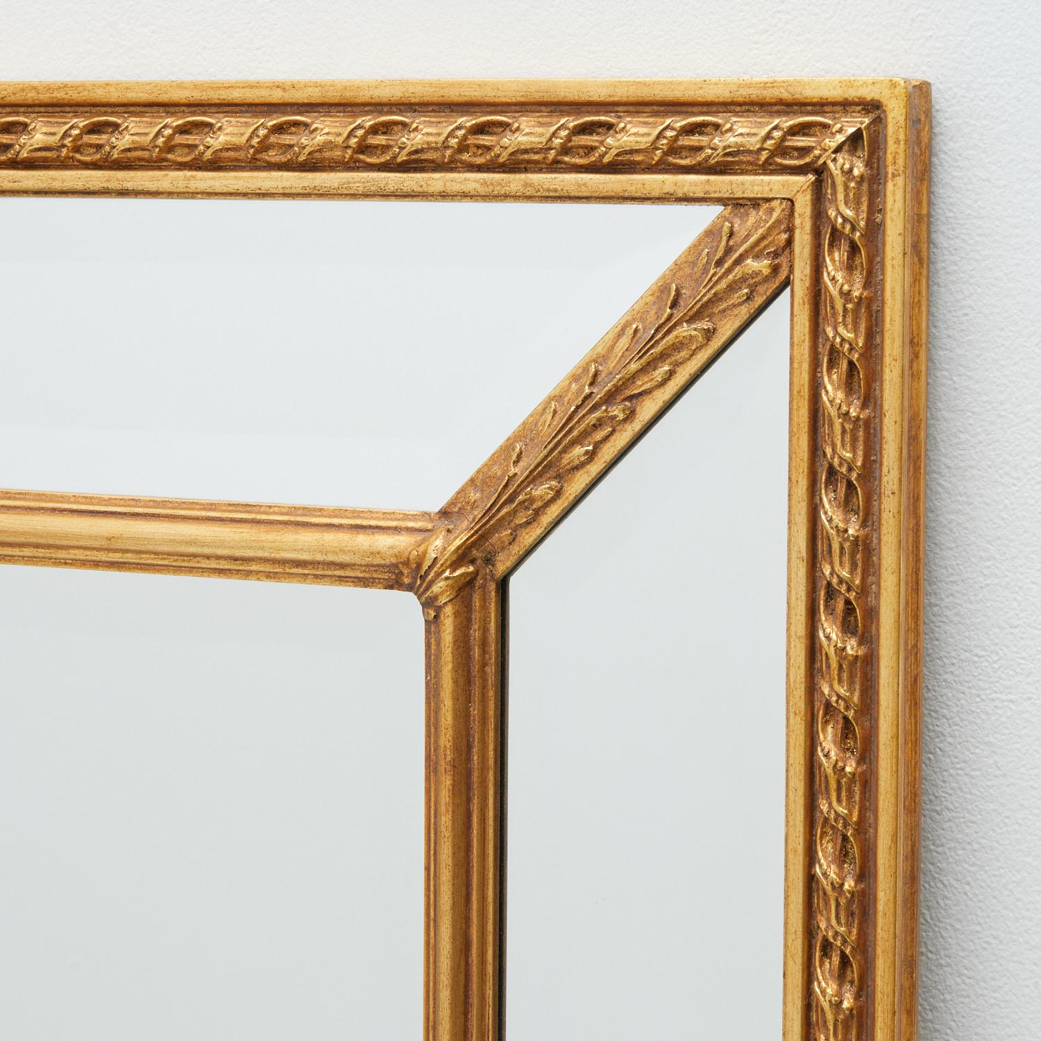 Late 20th c., American Carvers' Guild mirror style #1204. This double frame, combed and linked by acanthus frets, forms a striking linear pattern. Canted and beveled side panels, a beveled central panel, and an antique gold leaf finish make it