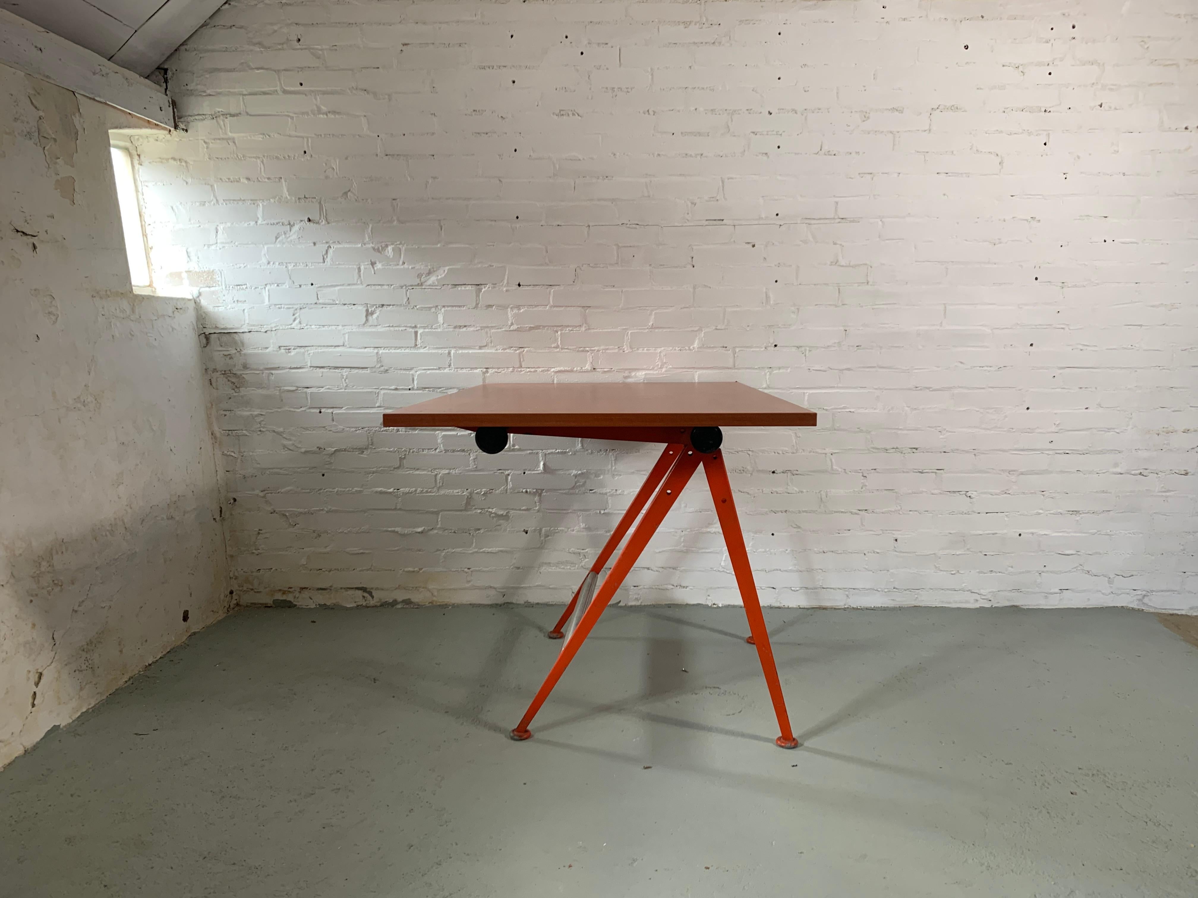 Classic Dutch design from mid century. Designed by Friso Kramer and Wim Rietveld. Great as the writing desk. Industrial design icon in very rare original red colour. Adjustable height and the position of the top. Top is new, made of plywood with