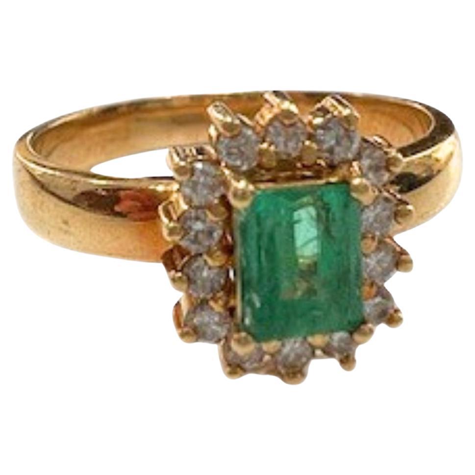 Contemporary design ring from the 20th century, crafted in 18k yellow gold. Featuring a vibrant emerald-cut emerald and brilliant-cut diamonds, this piece combines classic elegance with a modern flair.

Technical Details:
Metal: 18k Yellow