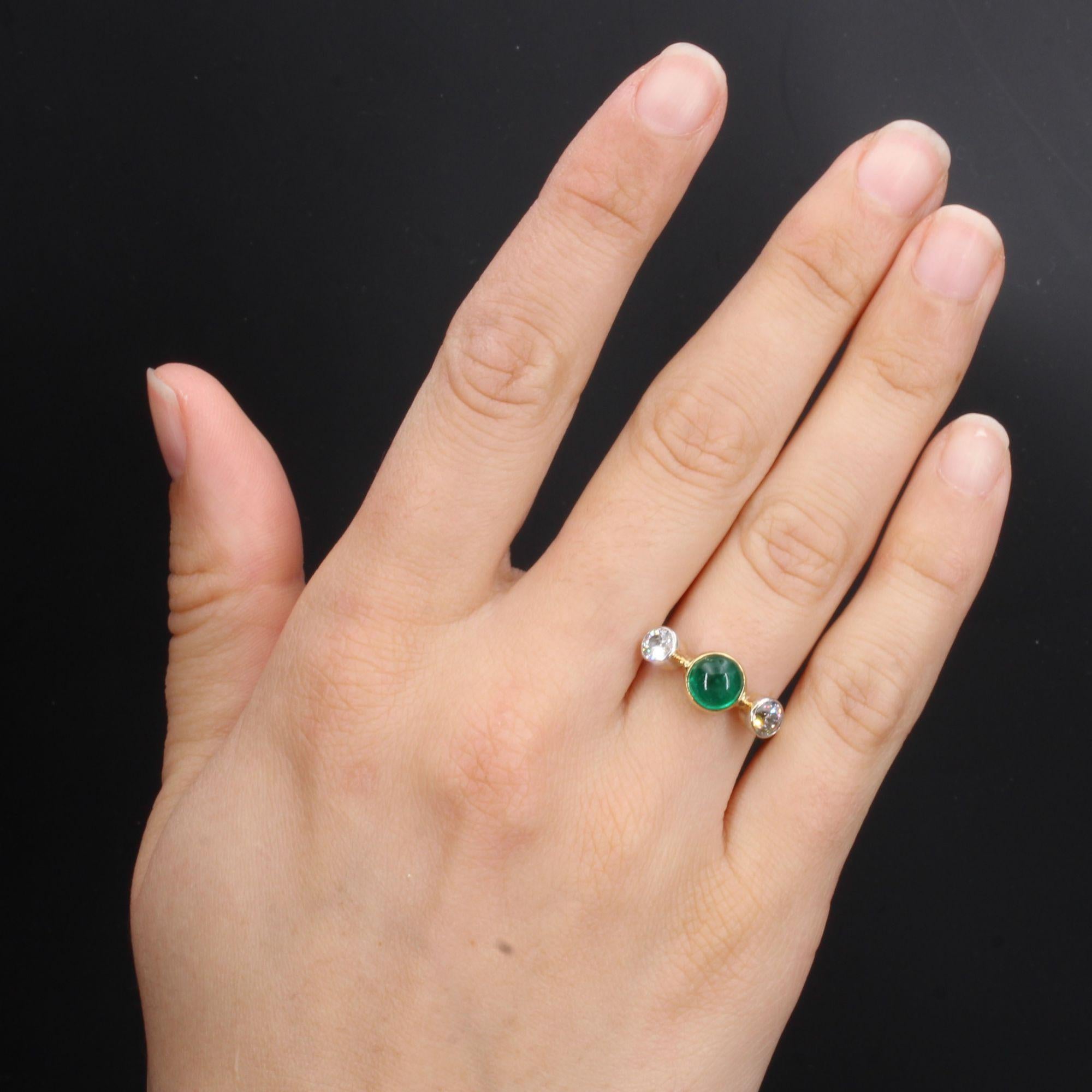 Bague en or jaune 18 carats.
Charmante bague ancienne, elle est ornée sur son dessus d'une émeraude cabochon ronde en serti clos, et épaulée de part et d'autre de 2 diamants anciens taille brillant également en serti clos. L'anneau est un fil d'or
