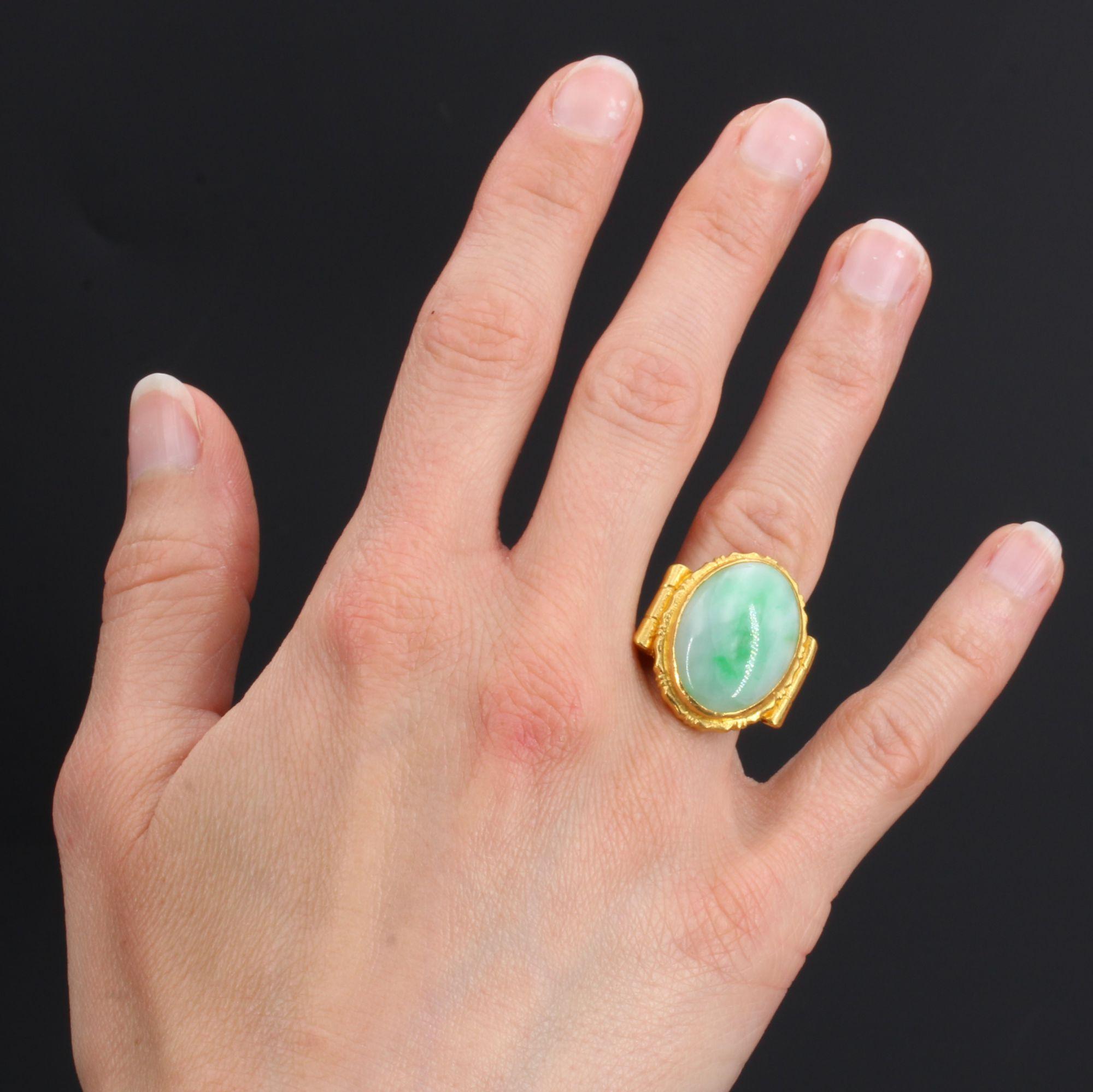 Ring in 18 karat yellow gold, owl hallmark.
Important antique ring, it is set with a cabochon of jade jadeite closed set, within a chased setting. On both sides of the head, the ring begins with an important chased gadroon which is then refined to