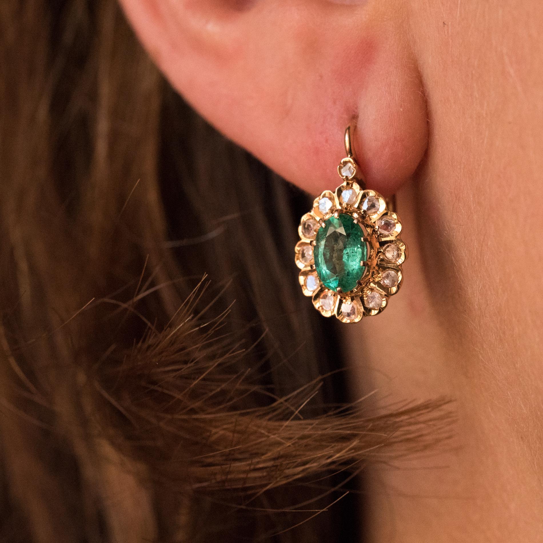 For pierced ears.
Earrings in 18 karats rose gold.
Lovely antique earrings, they are set with claws on their top of an oval emerald, surrounded by rose-cut diamonds, like a daisy. A rose-cut diamond overcomes the whole. The clasp system is from the